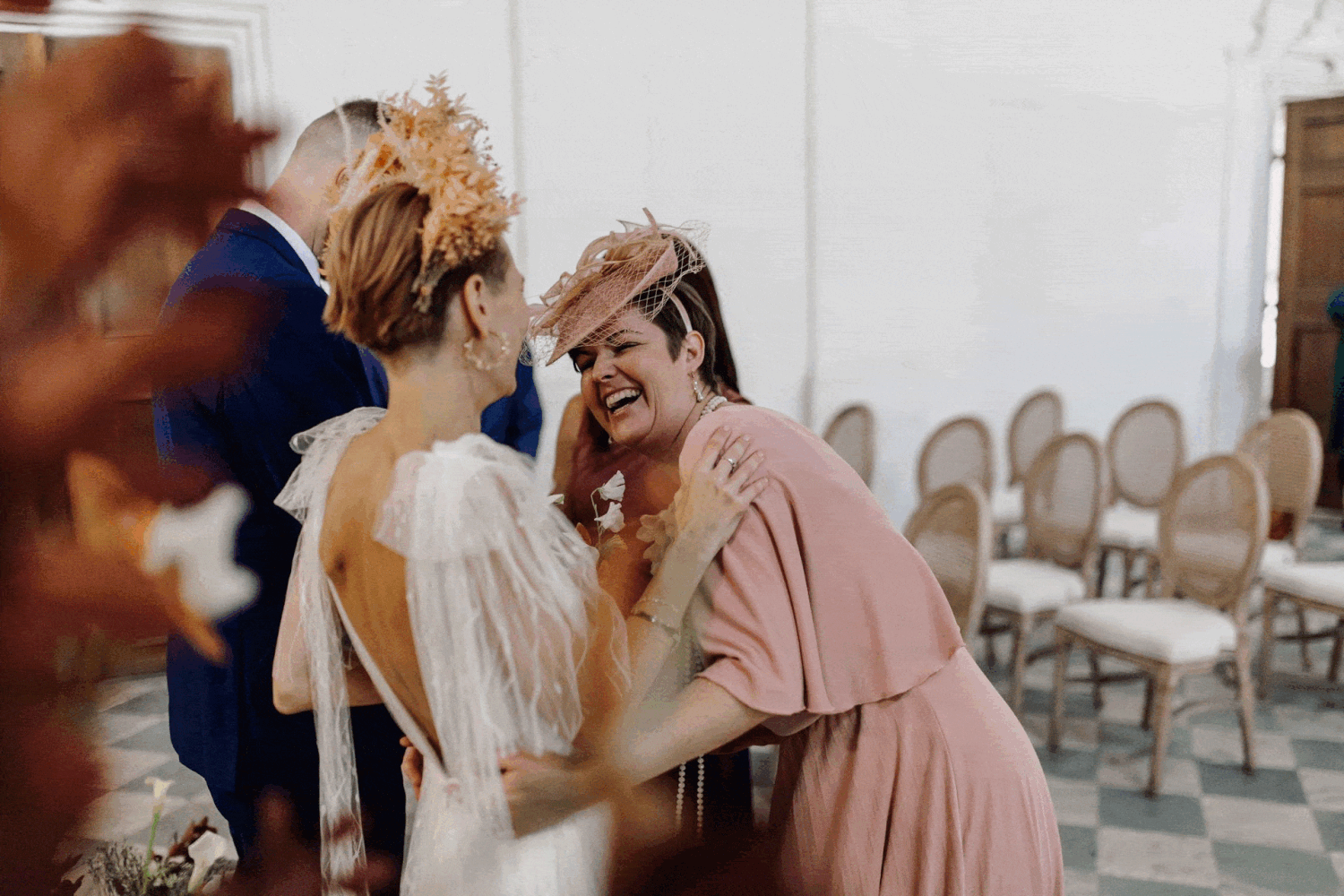 A joyful moment shared between wedding guests as they celebrate at an elegant indoor venue.