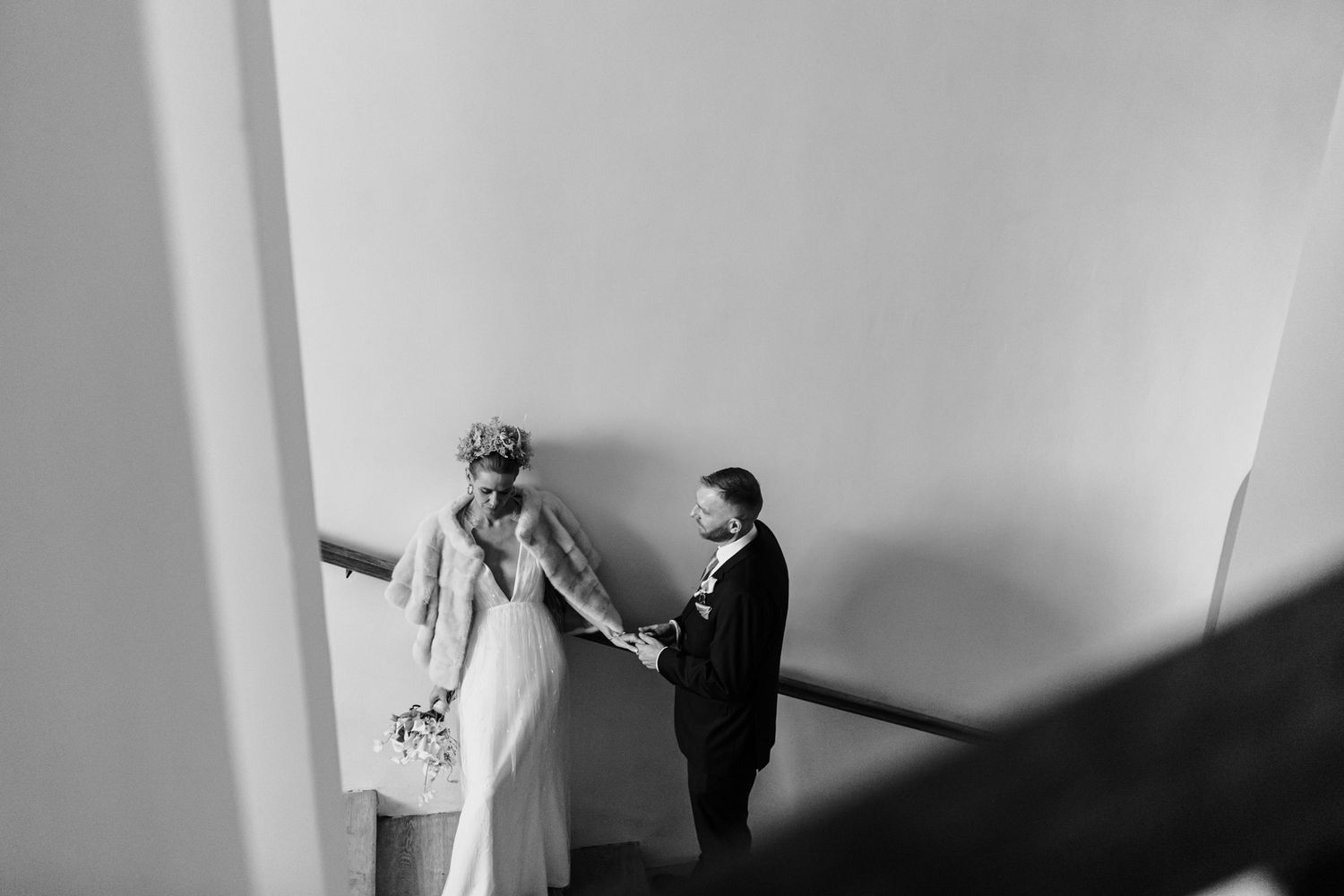 Black and white photo of newlyweds in minimalist setting with dramatic shadows.