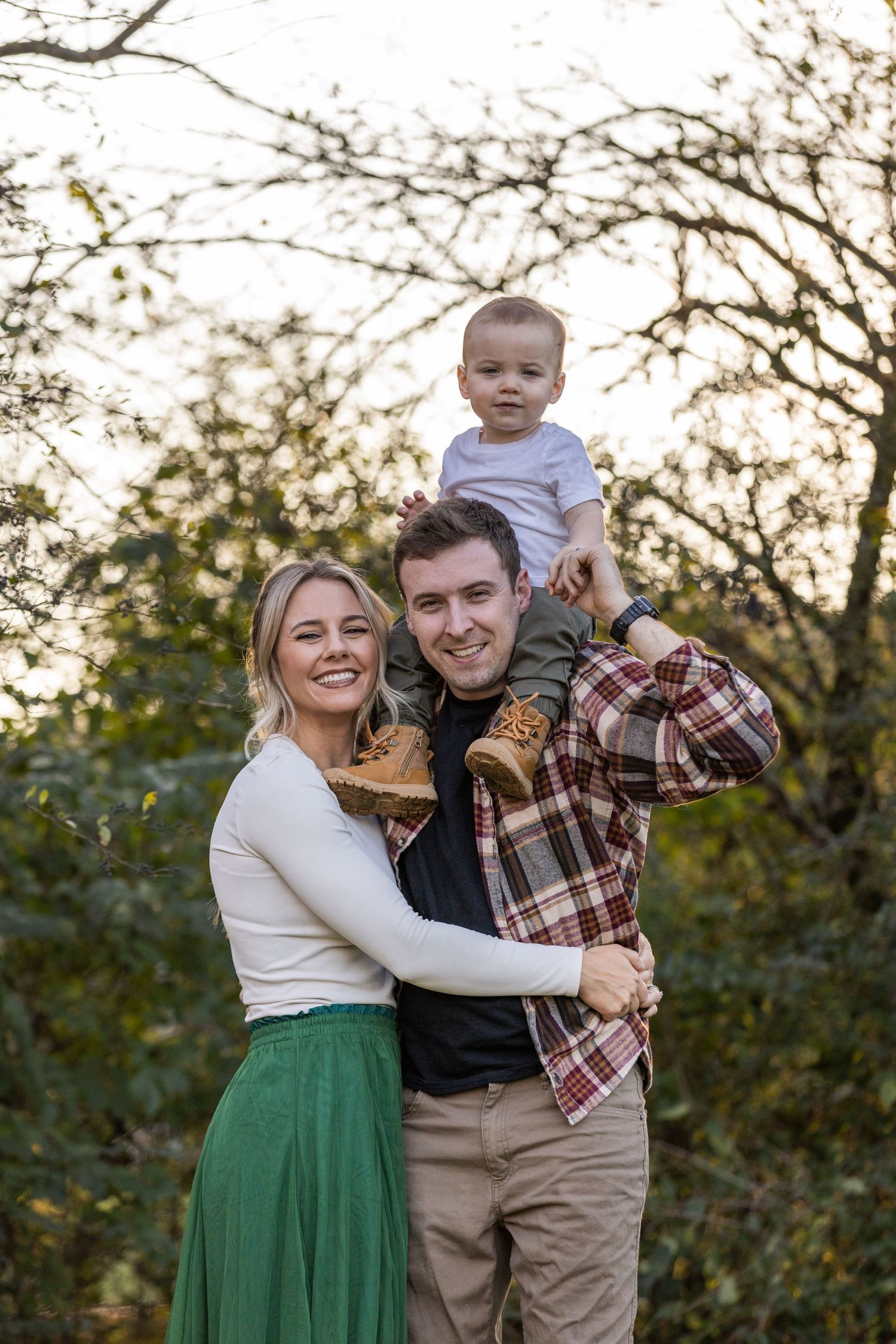 A family shares a happy moment together during an outdoor autumn photoshoot.