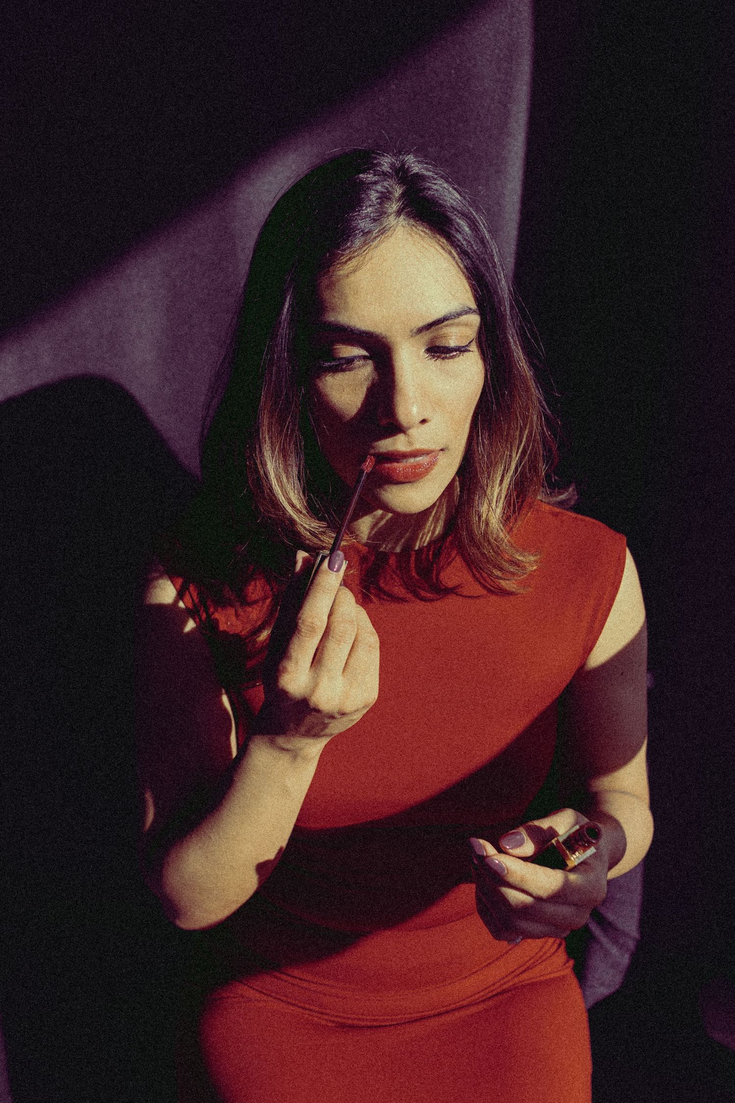 Editorial Portrait of Bhavya, an Indian woman applying Tom Ford lipgloss on herself, red and purple colour coded