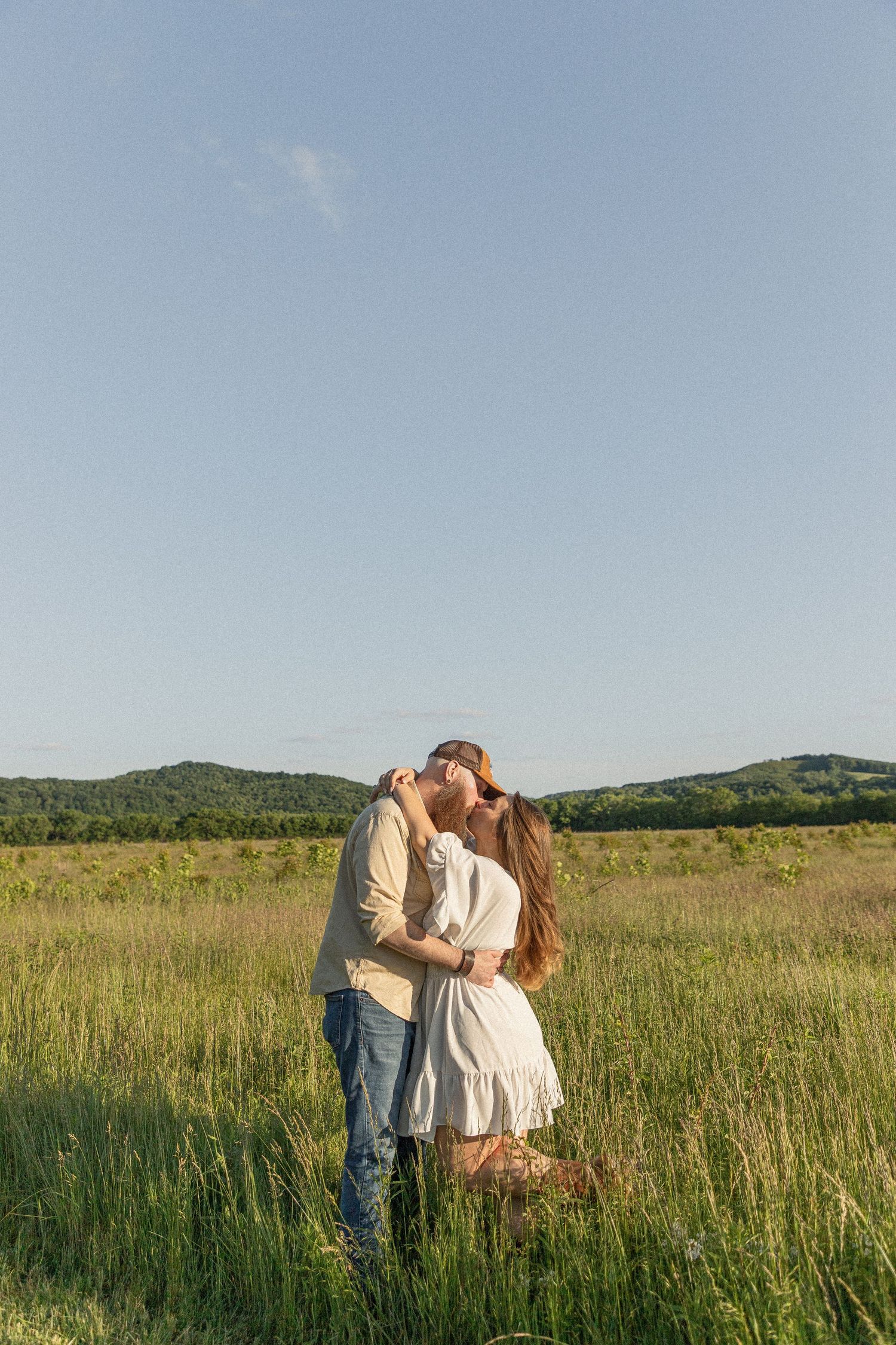 Ohio wedding photographer - Adeva Rae Photography - Couple in field with hills - western attire.