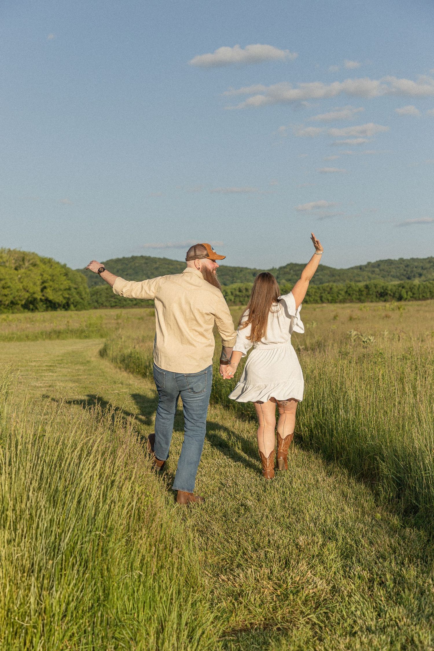 Ohio wedding photographer - Adeva Rae Photography - Couple in field with hills - western attire.