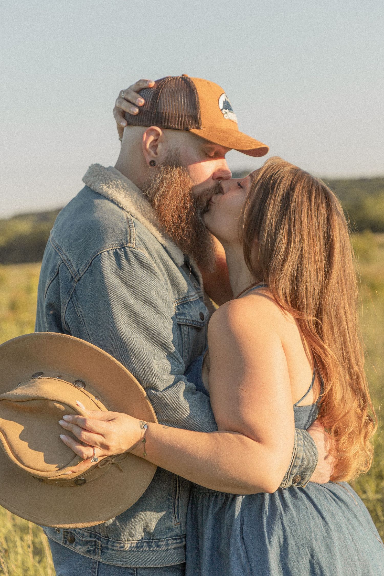 Ohio wedding photographer - Adeva Rae Photography - Couple in field with hills - western attire.