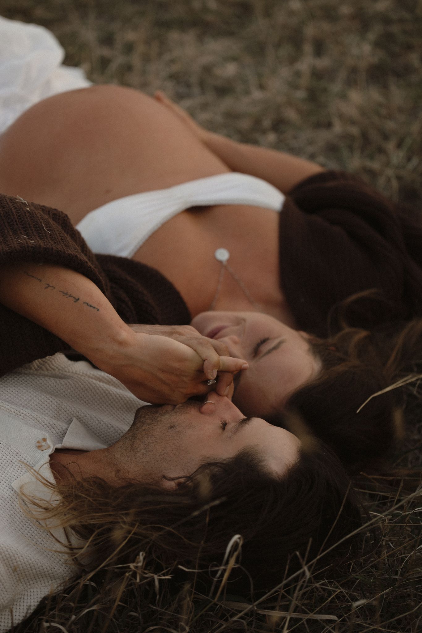 Person lying down on grass in artistic boudoir photography series with soft lighting.