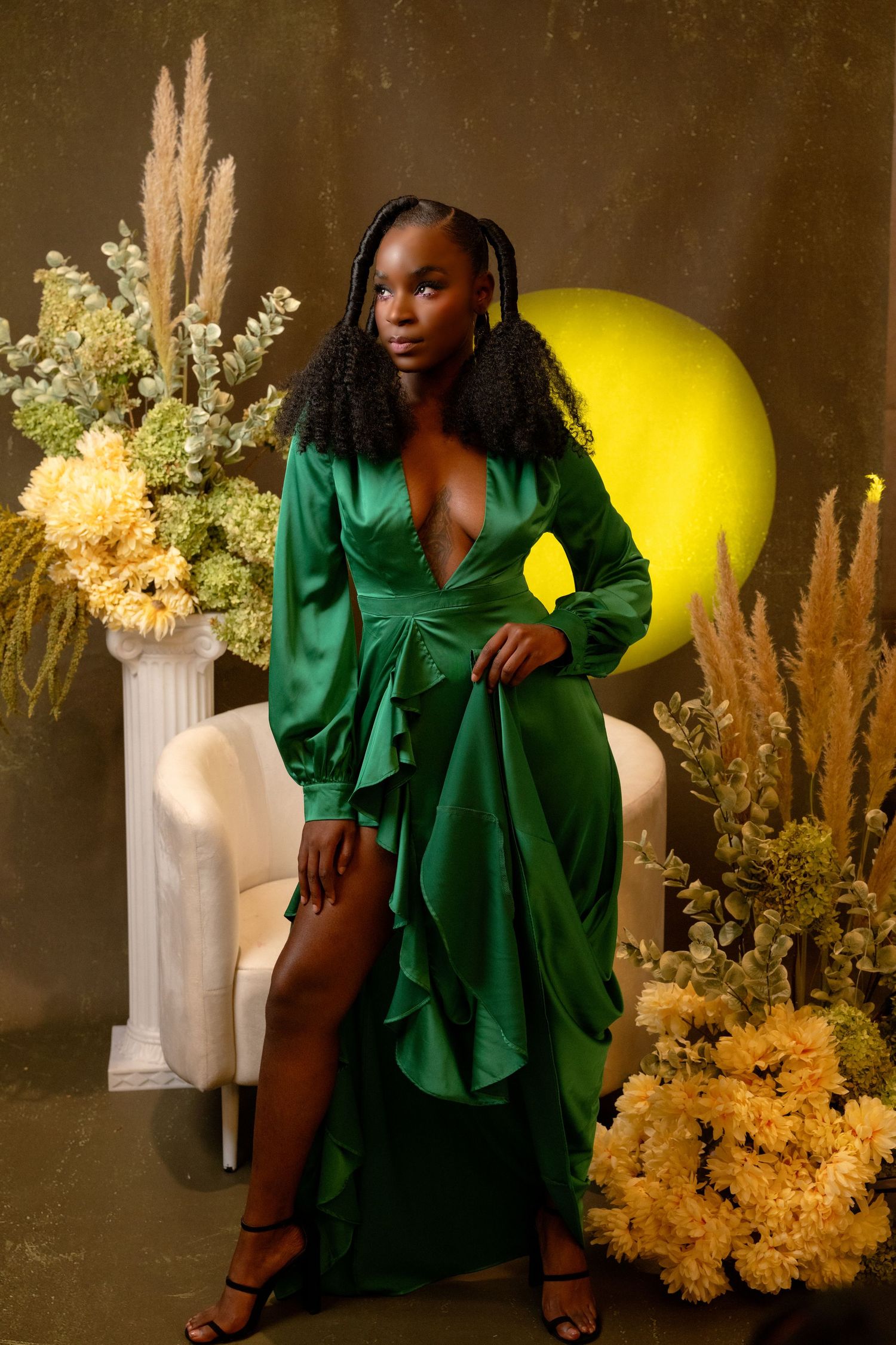 Woman in a deep green silk dress poses in a lush indoor setting, designed for Fort Lauderdale studio portraits with flair and elegance.