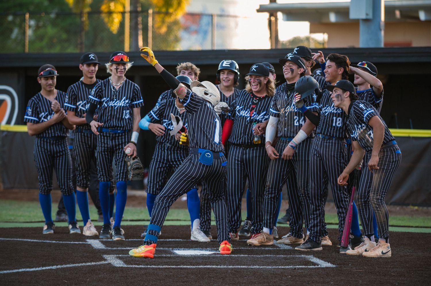 Homeplate celebration by players and batter who hit a homerun during a high school game in Broward County, FL. Sports Photography South FL