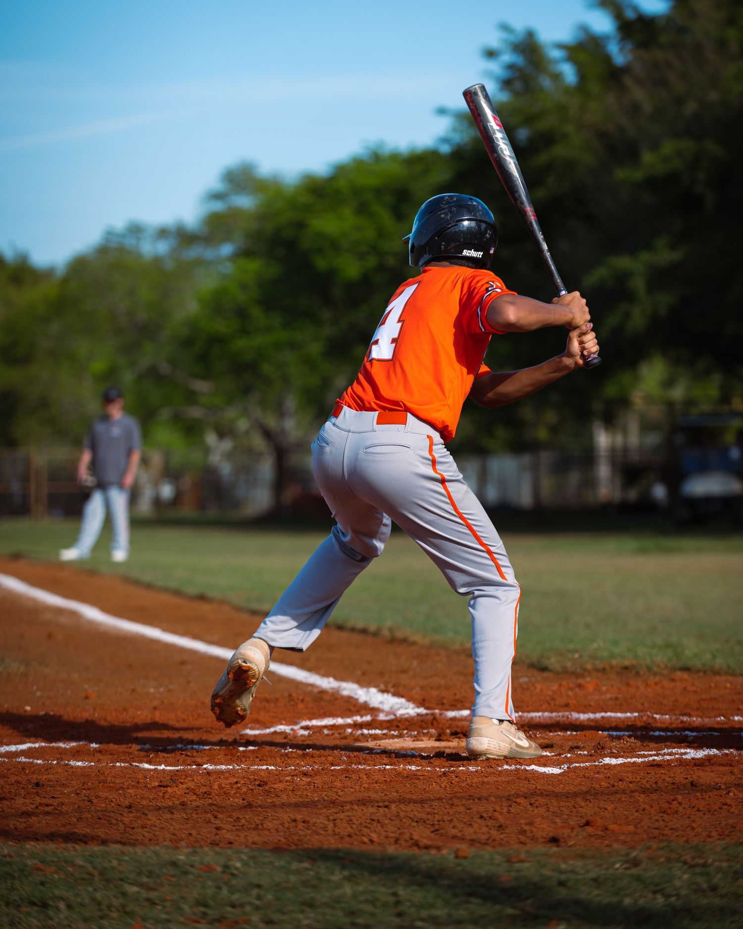 Batter load in his stance in anticipation of the pitch at sunset during a high school baseball game. Fort Lauderdale Photographer for hire