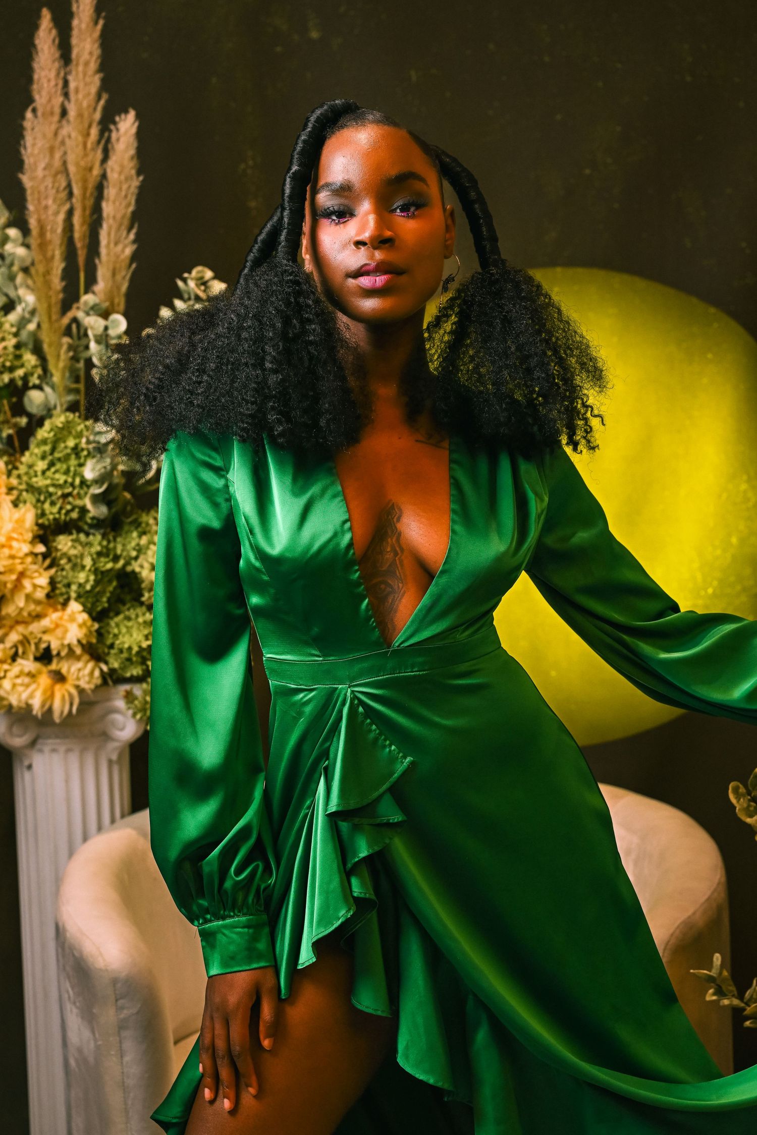 Elegant woman in emerald gown poses indoors for best Fort Lauderdale portrait photographer.