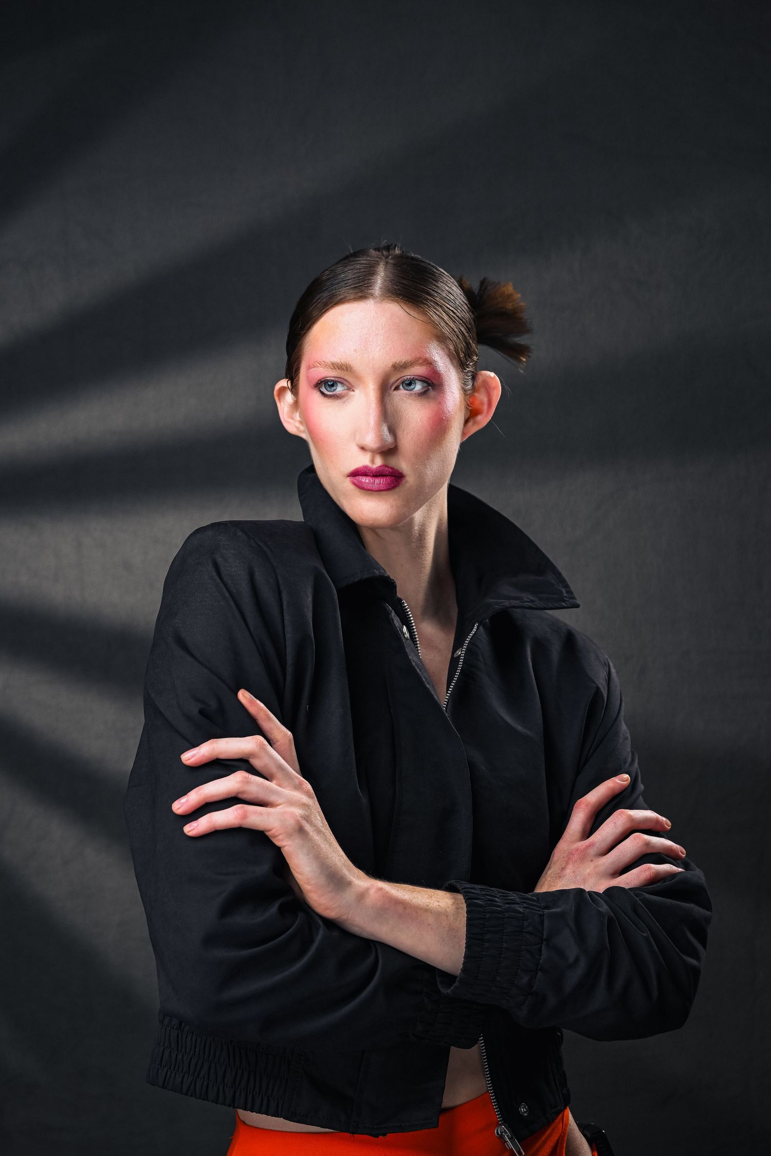 Woman in jacket with bold makeup against dark background in studio shoot. Best Fort Lauderdale portrait photographer Ur The Focus.