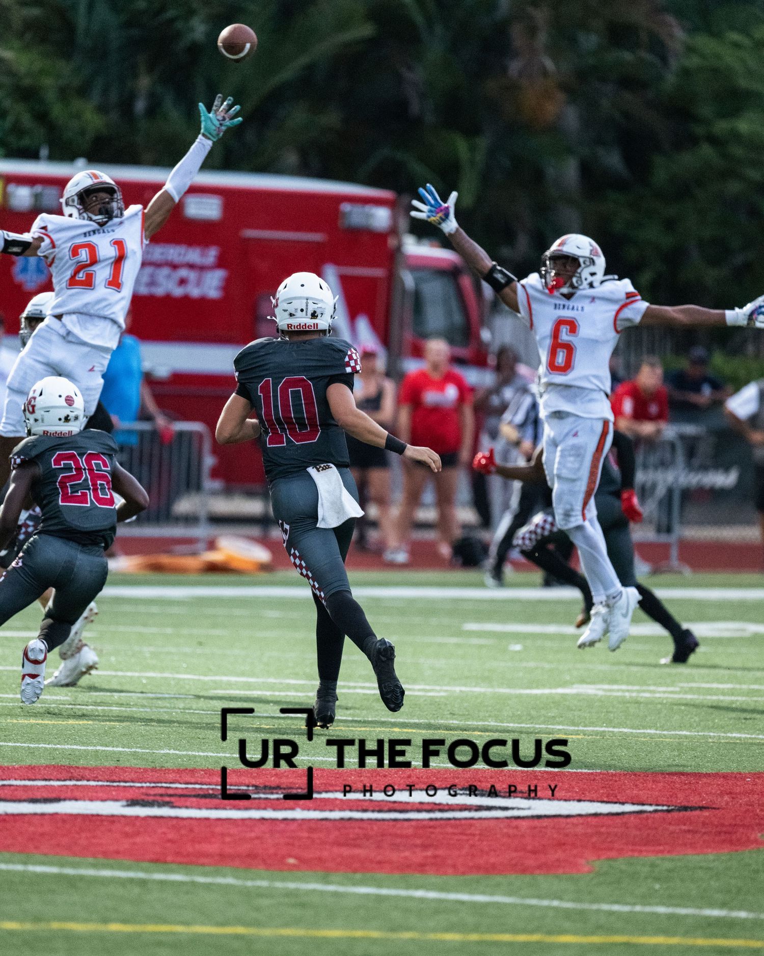 Defenders leaping for catch mid-air under stadium lights in Broward County. Fort Lauderdale Sports Photographer