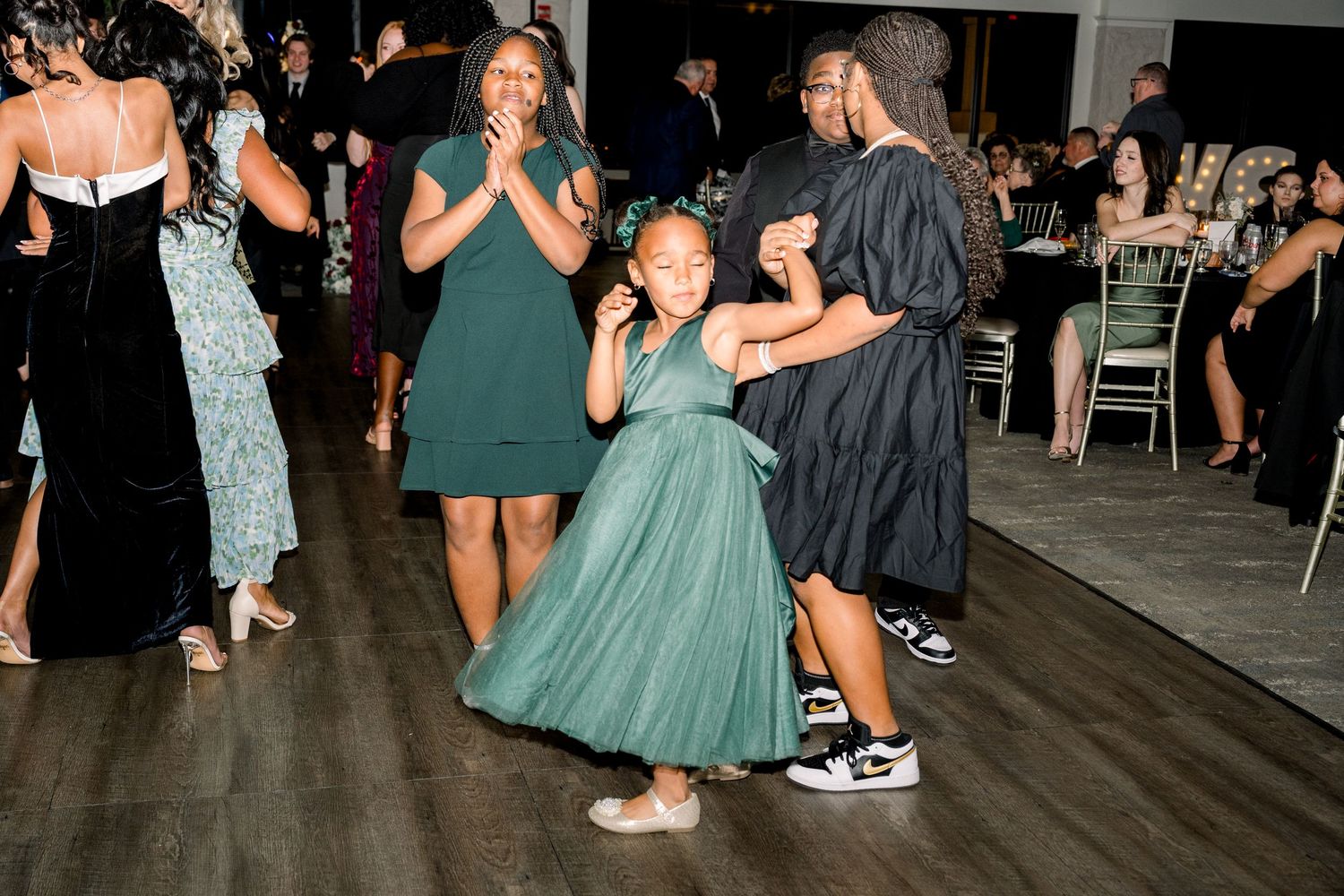Wedding guests dancing and enjoying celebration on reception dance floor.