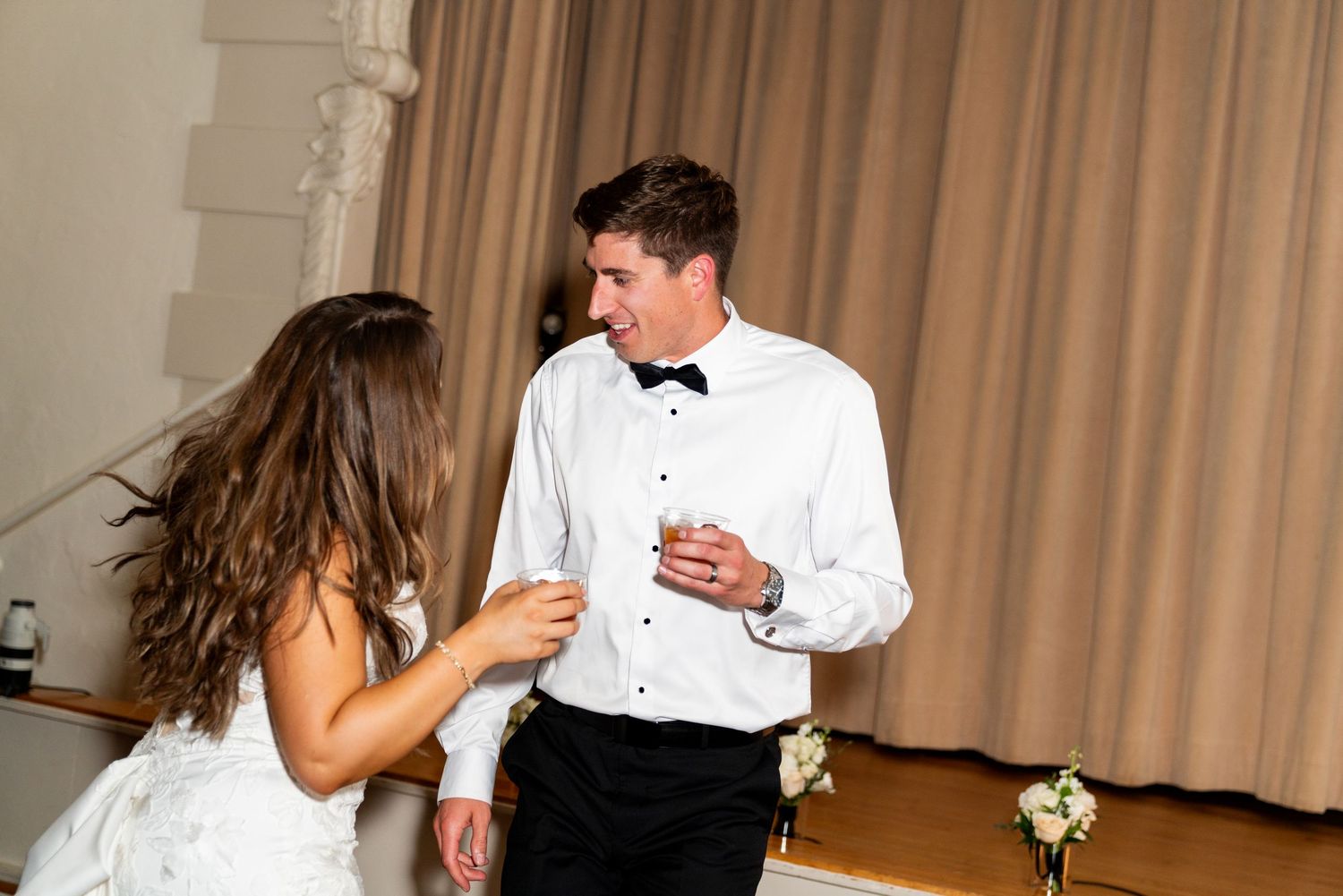 A candid moment of dancing and celebration during a wedding reception indoors.