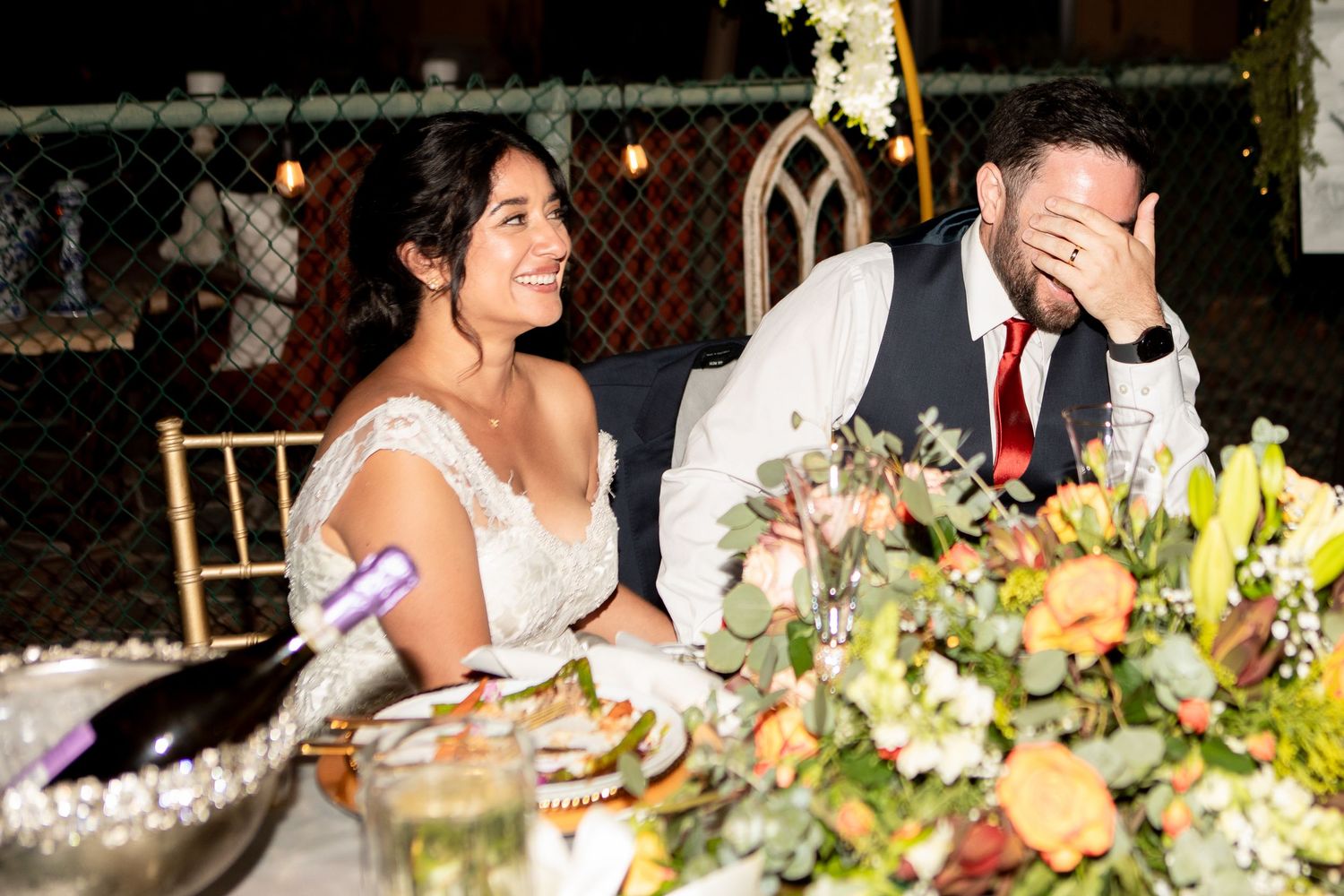 A candlelit wedding reception table with laughter and joy shared between guests.