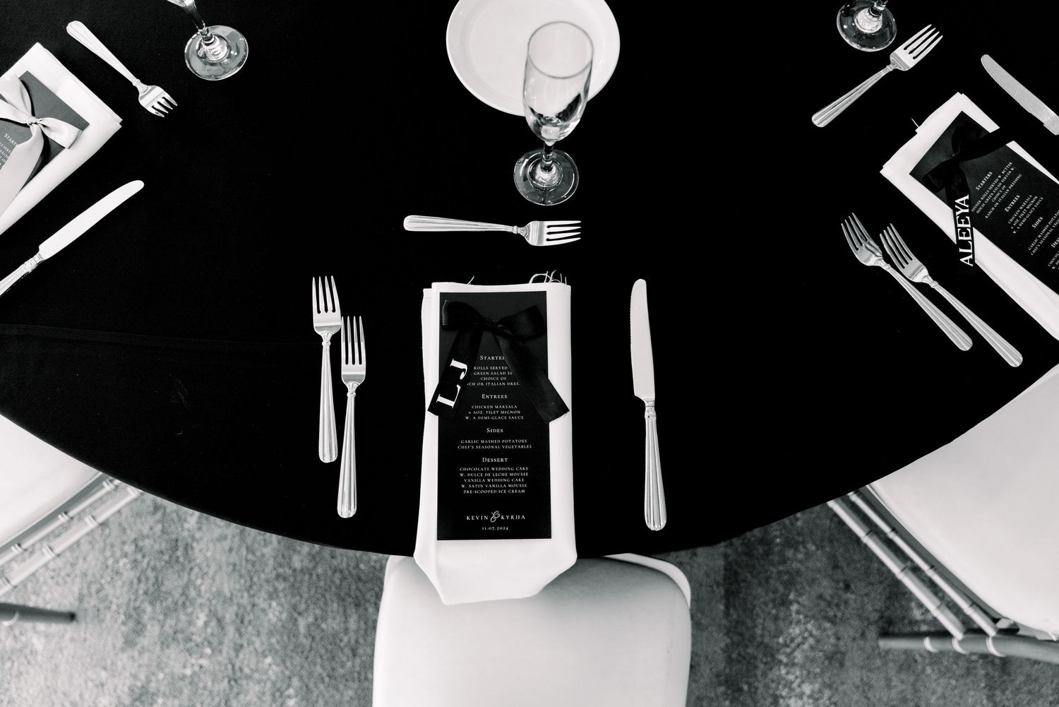 Overhead view of elegant black and white wedding reception table setting.