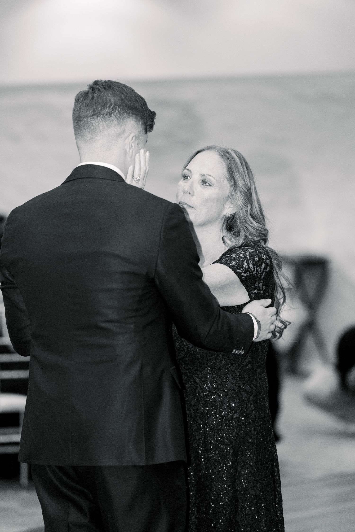 A couple shares an intimate dance moment at an elegant black and white formal event.
