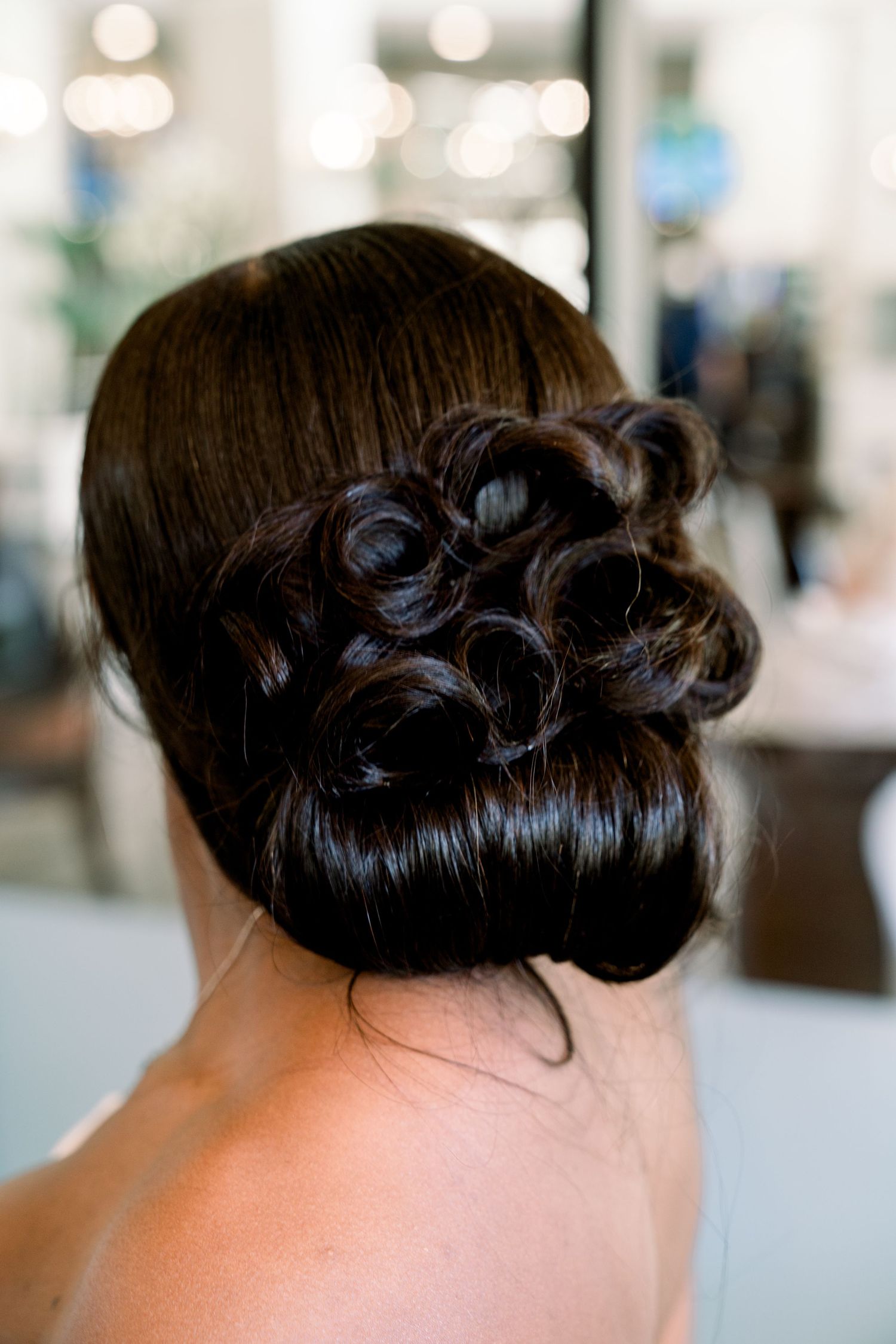 Elegant bridal updo hairstyle with dark curls styled in a sophisticated bun.