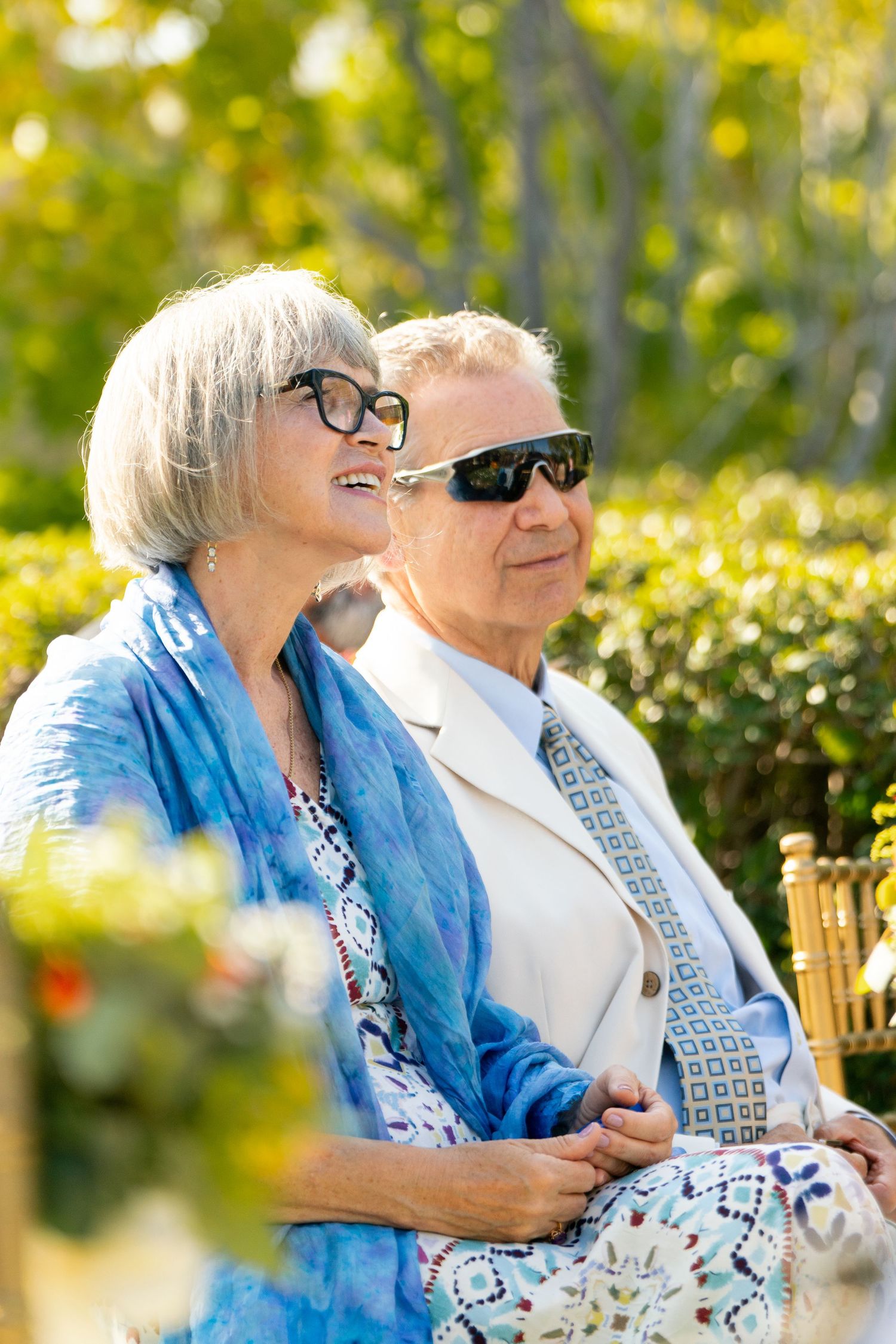 Wedding guests enjoying a sunny outdoor celebration in summer garden attire.