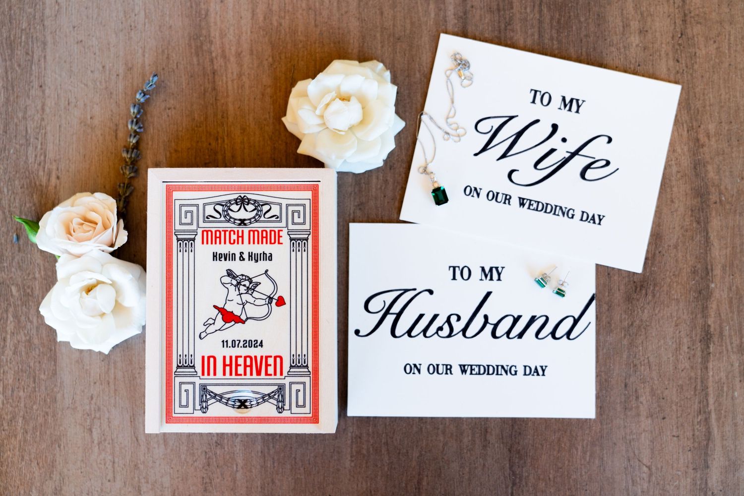 Wedding day cards to husband and wife with red playing card deck and white roses on wooden surface.
