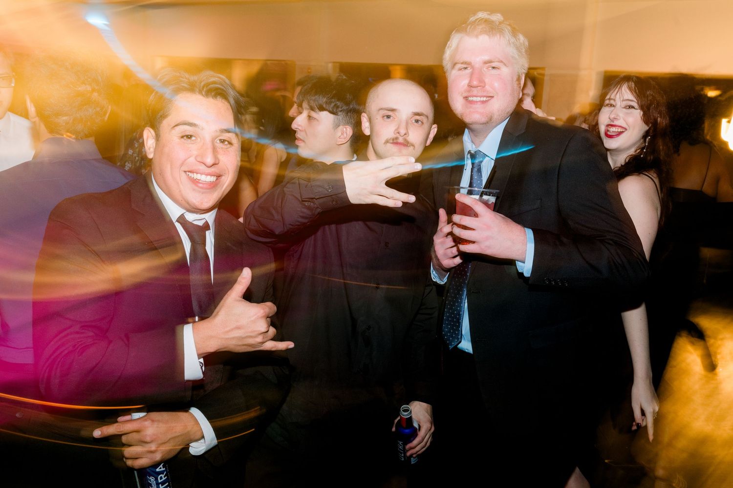 Party guests celebrating at a formal event with joyful expressions and festive energy.