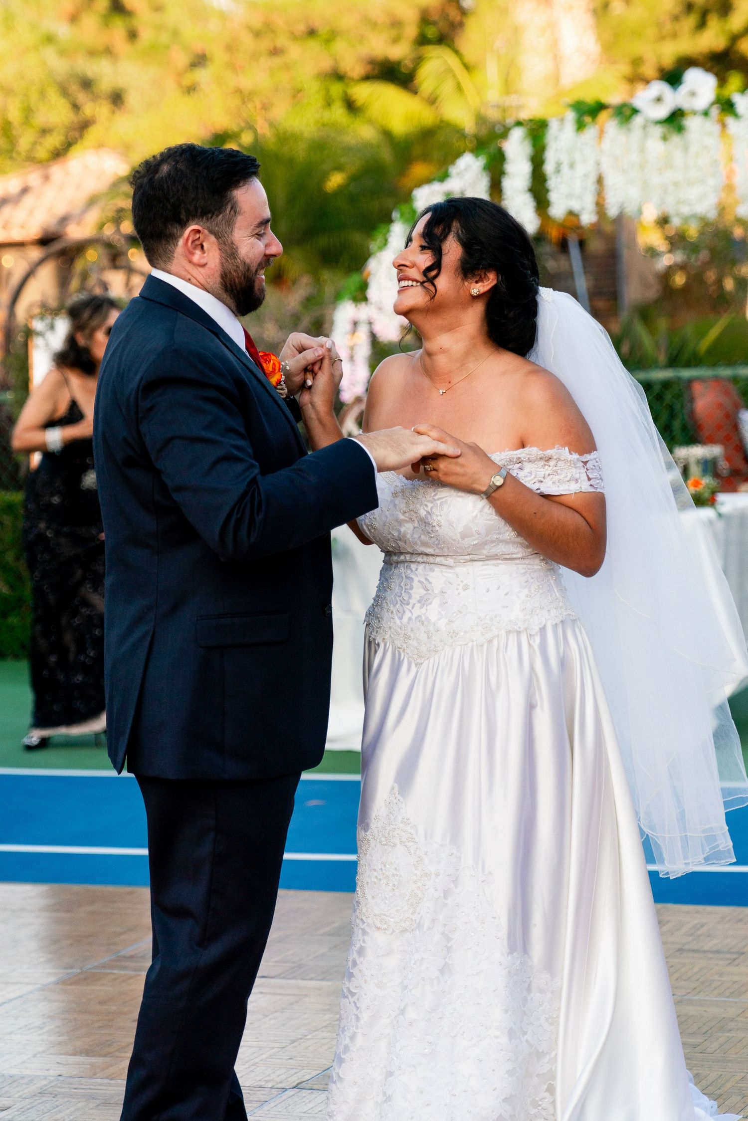 Couple shares joyful moment while dancing together at outdoor wedding reception.