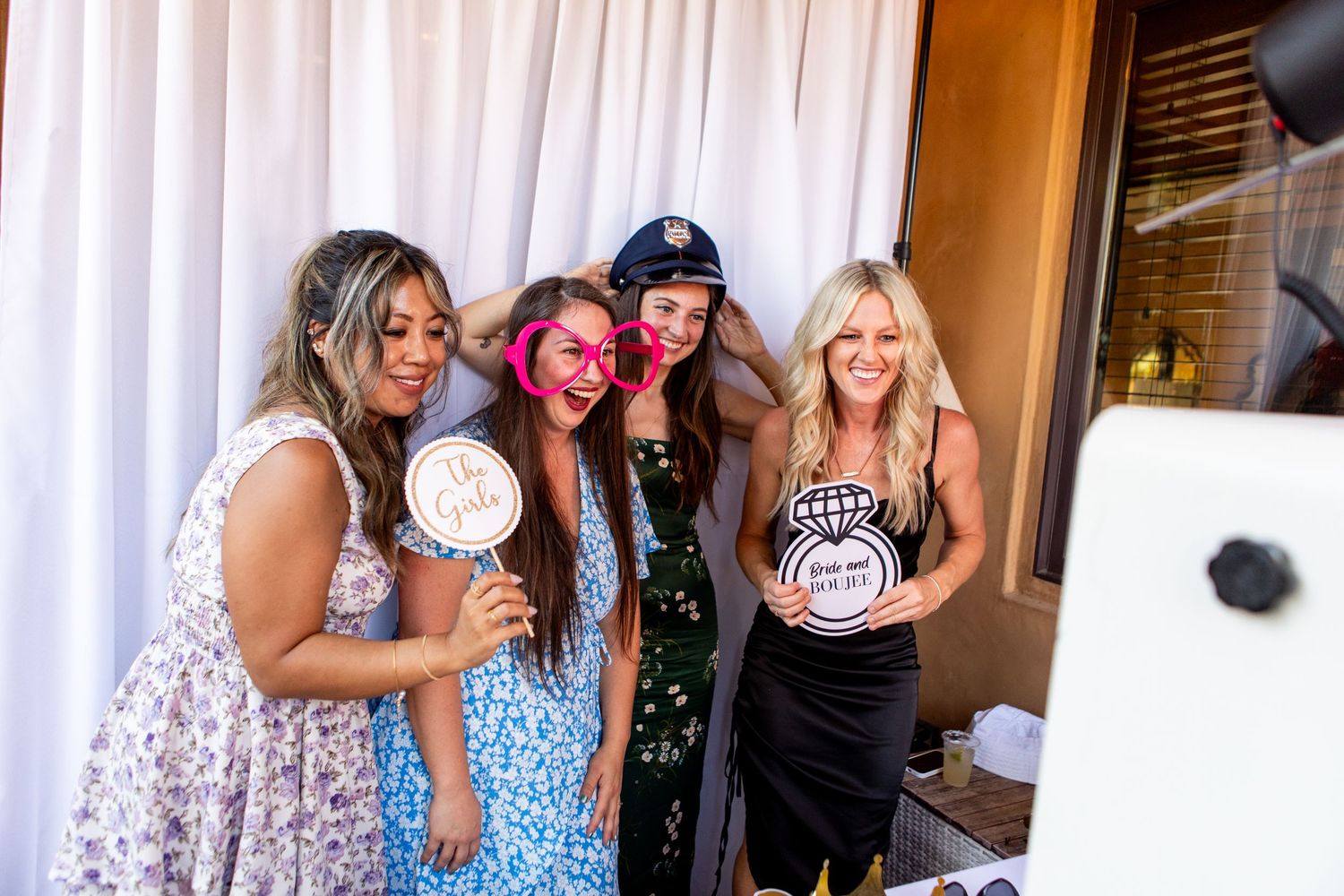 Group of wedding guests posing together with fun props at a photo booth.