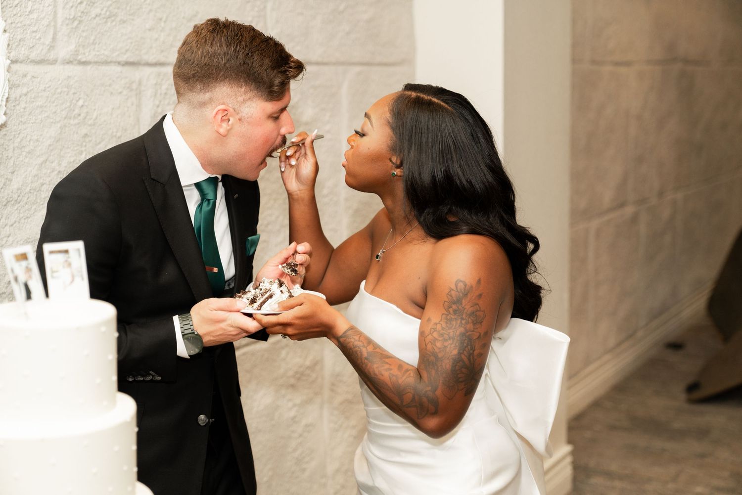 Playful cake cutting moment at wedding reception.