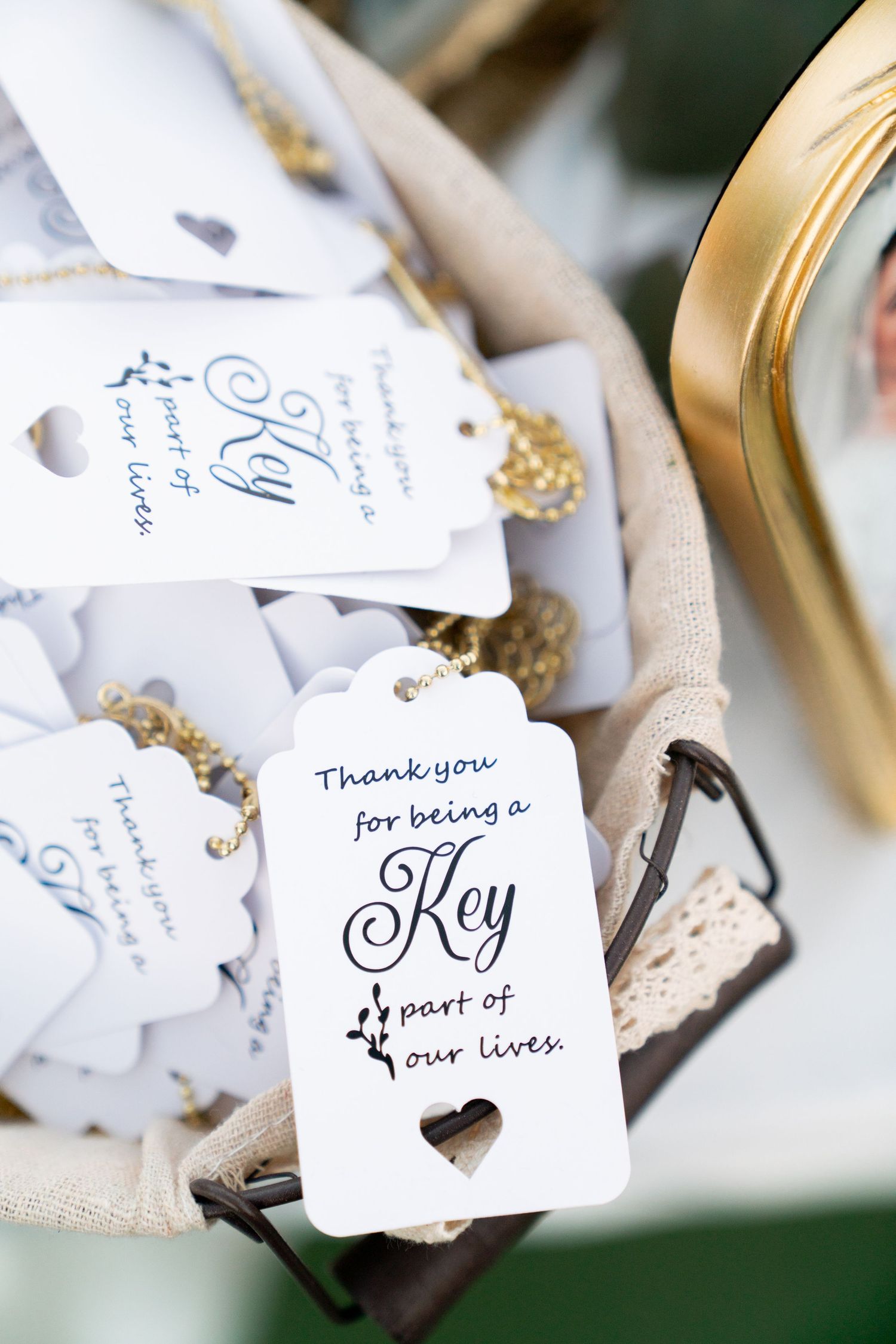 White wedding favor tags with 'Thank you for being a Key part of our lives' text and heart cutout.