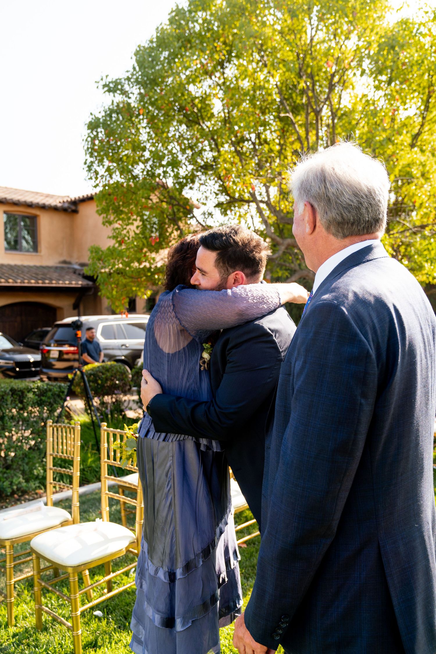 An emotional moment shared between guests at an outdoor wedding venue with Spanish architecture.