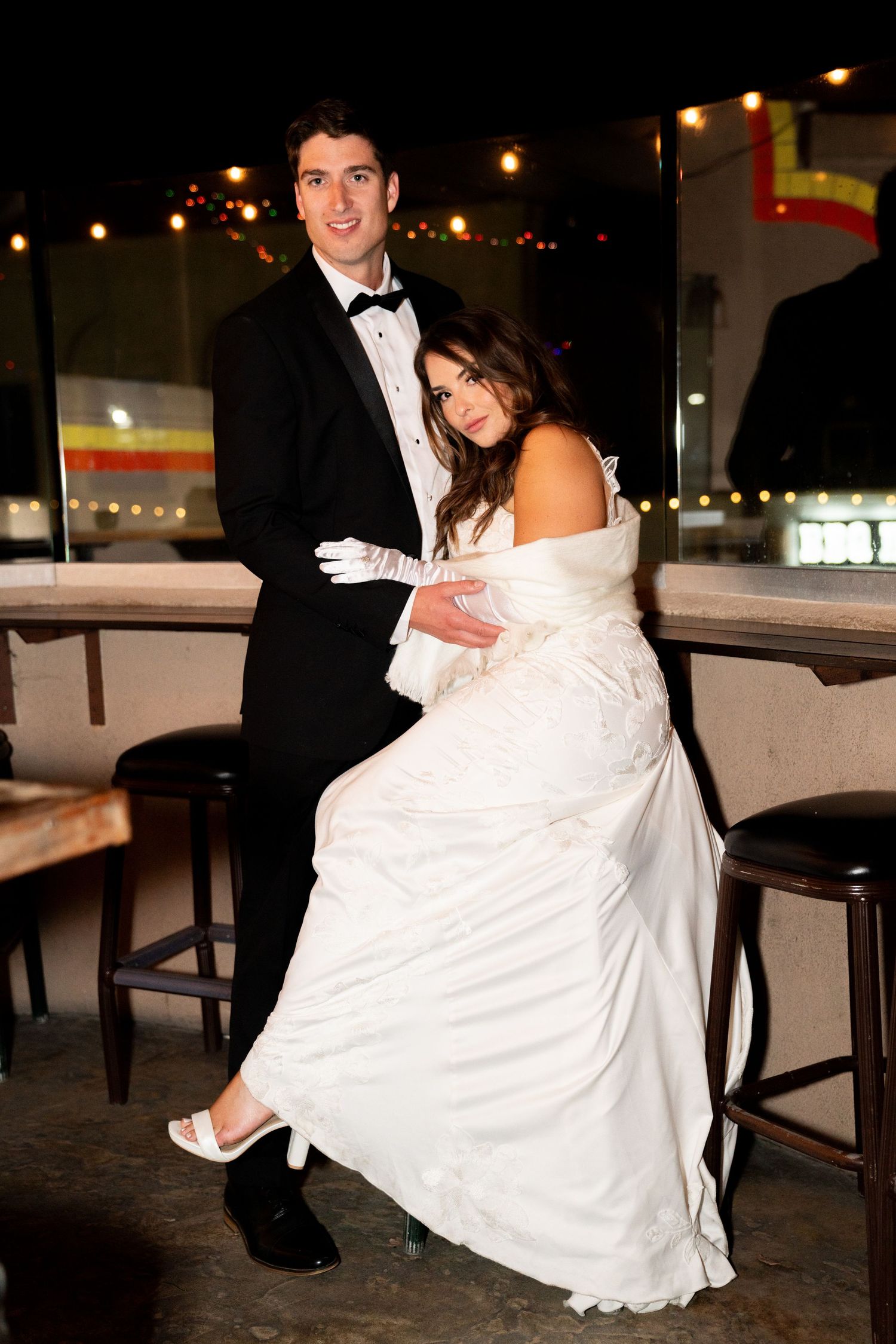 A romantic nighttime wedding photo with string lights creating a magical atmosphere.