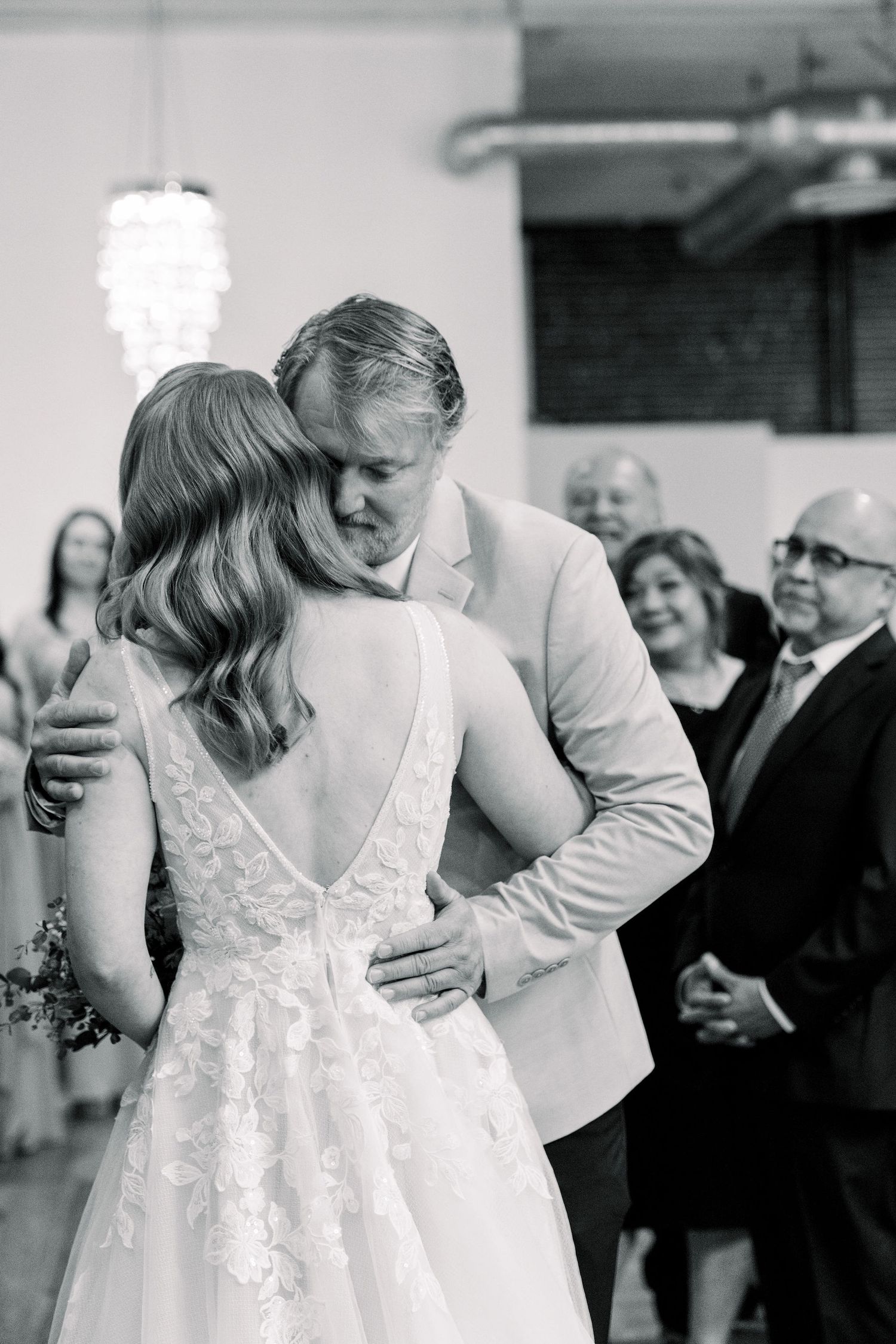 A tender black and white wedding photo showing a couple sharing an intimate moment during their first dance.
