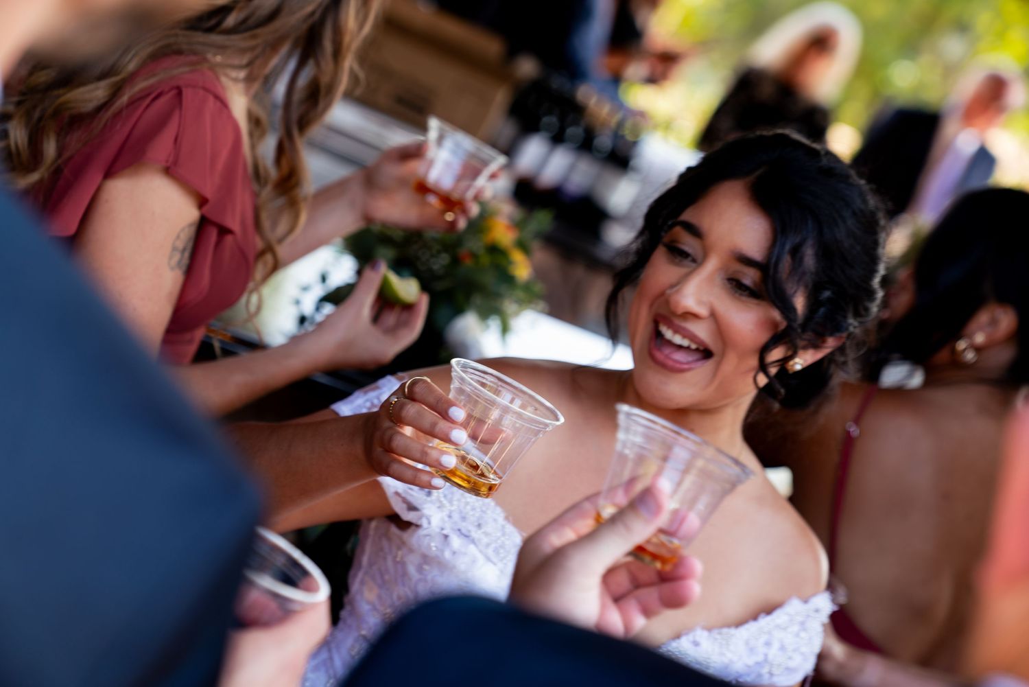 A celebratory moment at a wedding reception with guests sharing drinks and laughter.