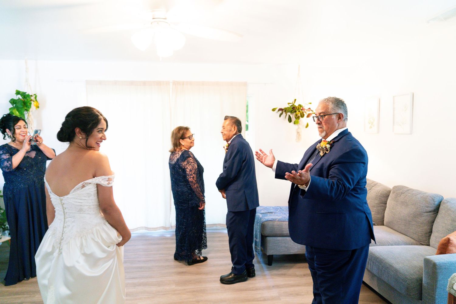 Candid moment of wedding party members having animated conversation in bright indoor venue.