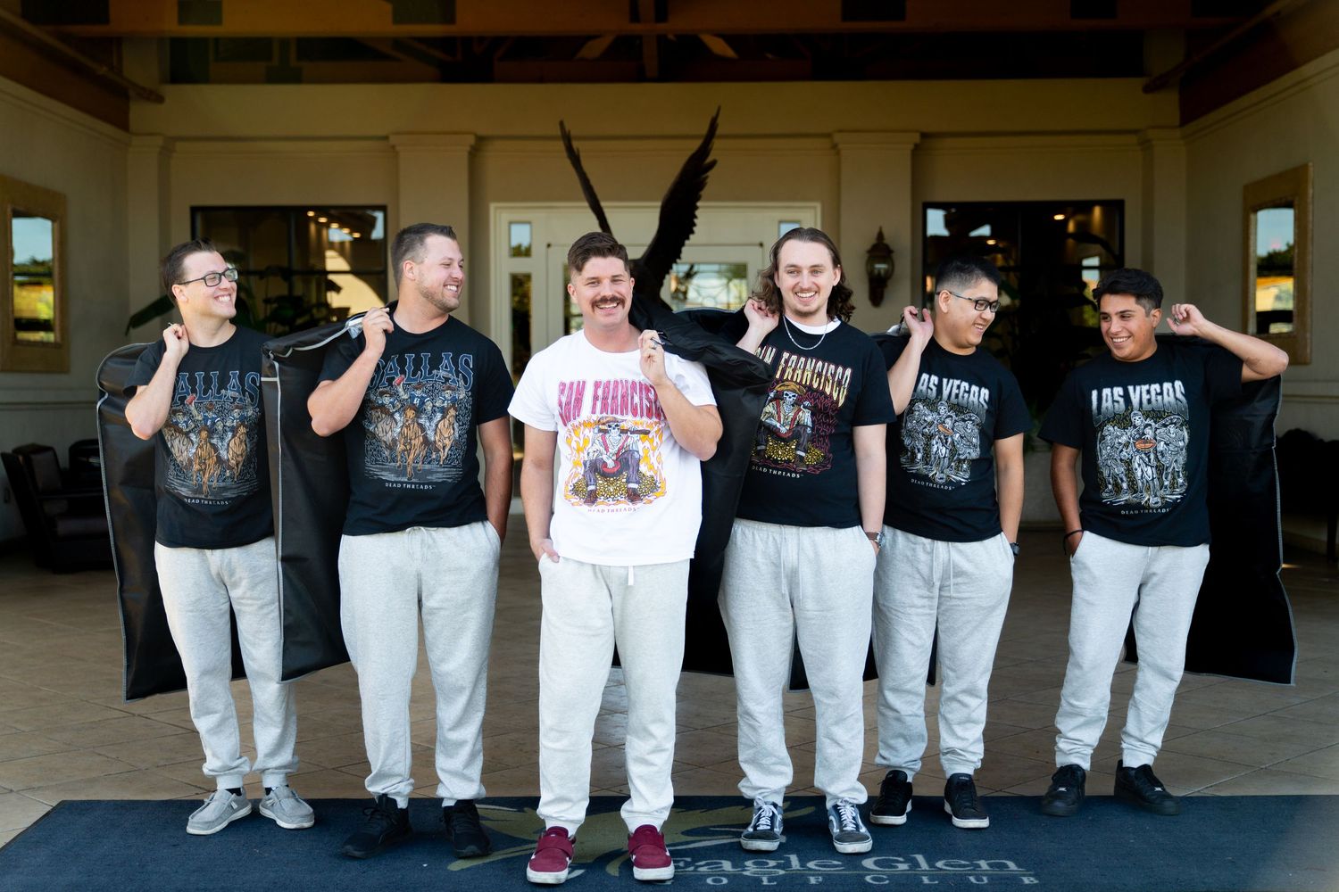 Group photo of wedding party members in matching t-shirts posing together.