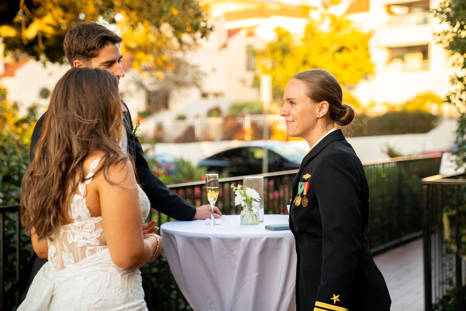 A wedding reception moment captured on an outdoor terrace with golden hour lighting.