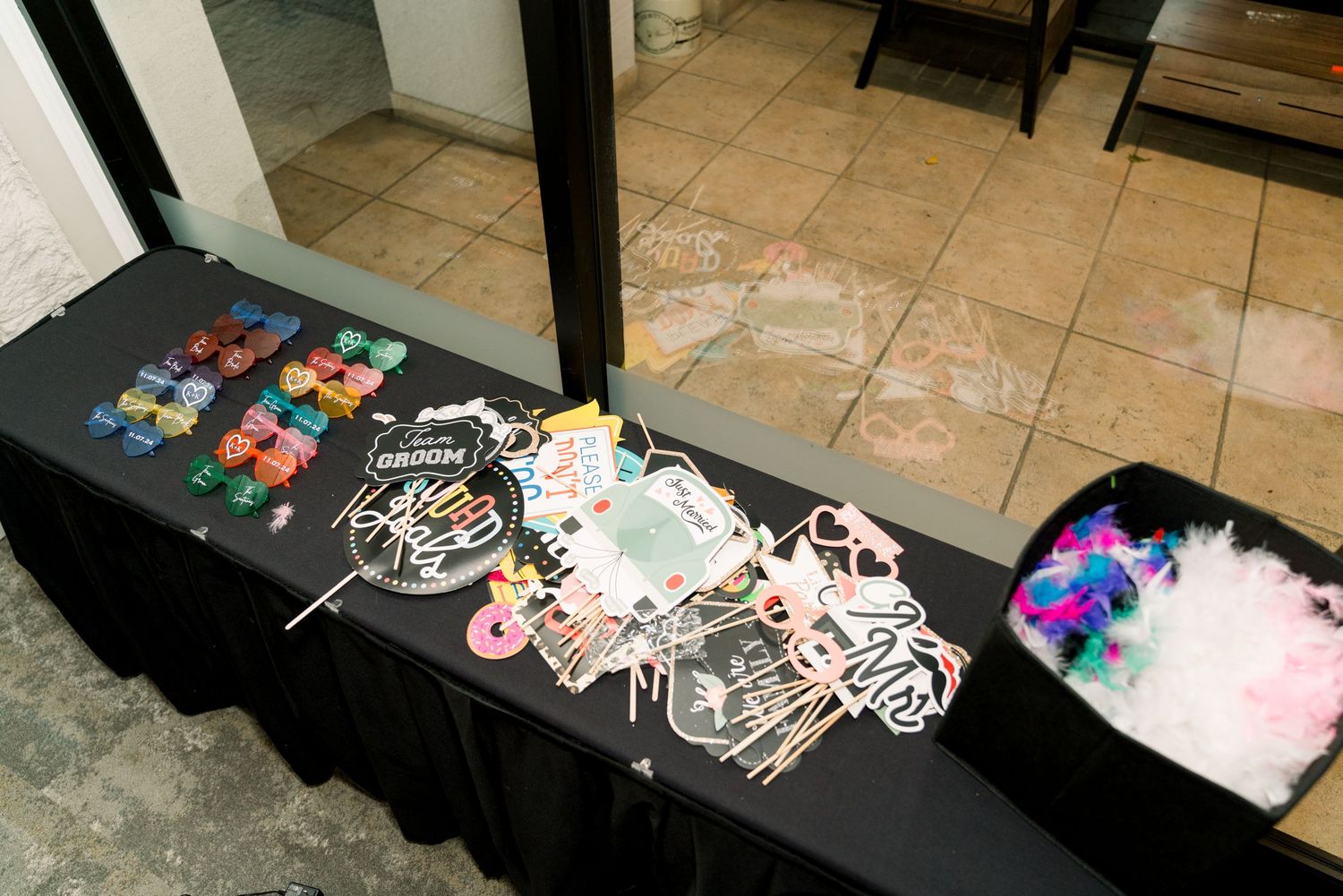 A table displays colorful party favors and accessories at a wedding reception.