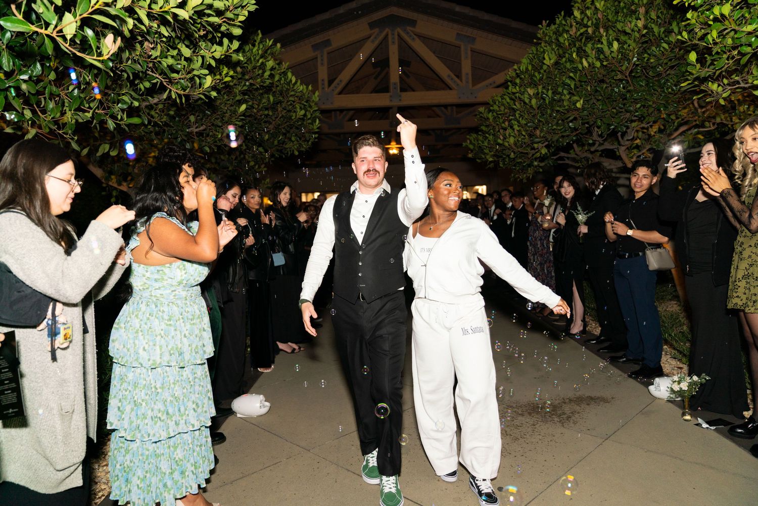 Wedding guests celebrating and dancing together during an outdoor evening reception.