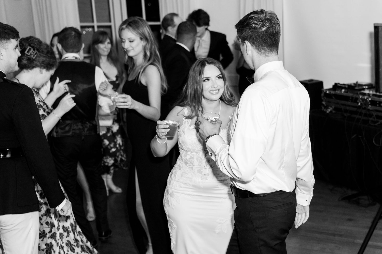 Black and white photo of wedding reception with guests dancing and celebrating.