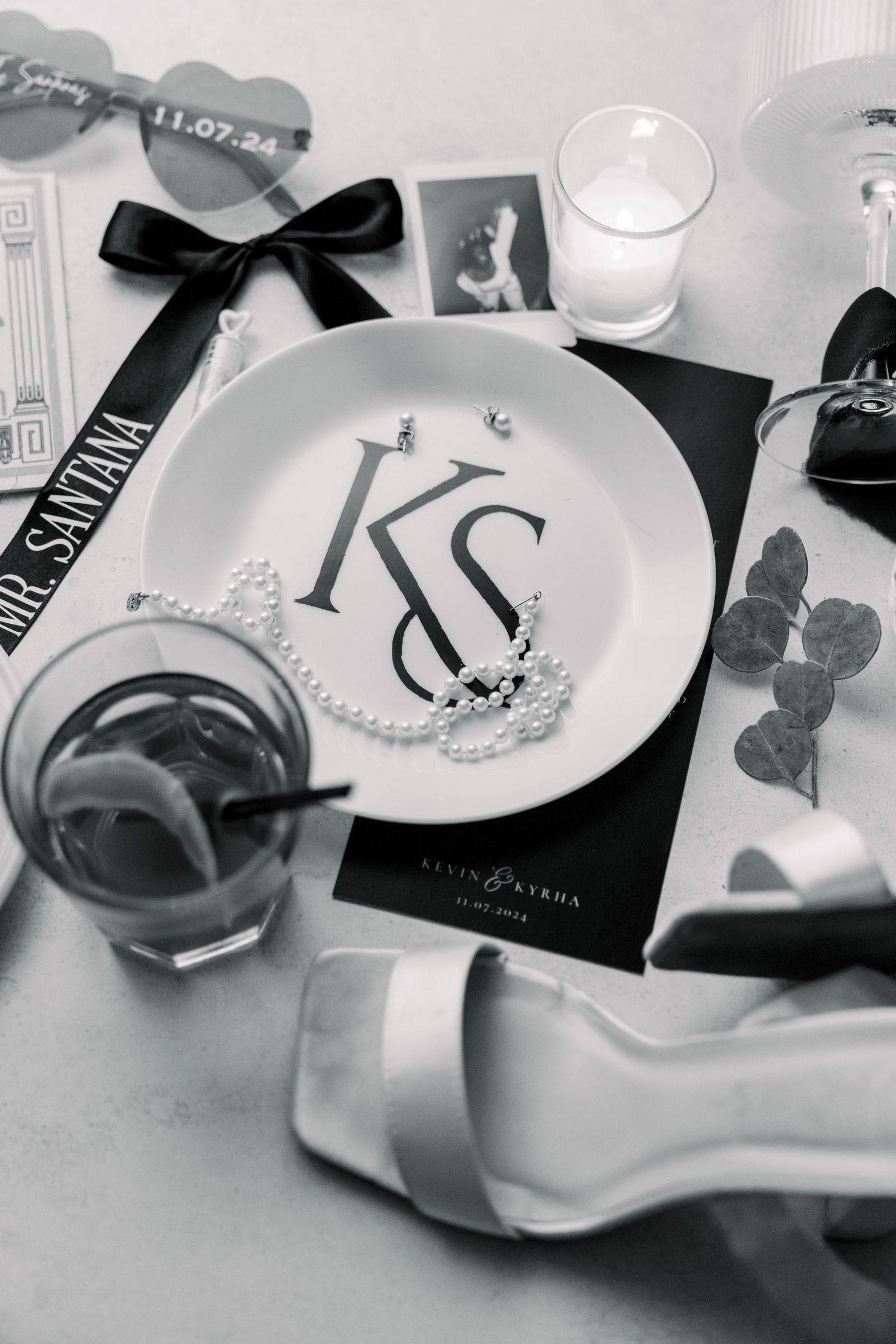 Black and white wedding decor featuring monogrammed plate with KS initials and black bow accents.