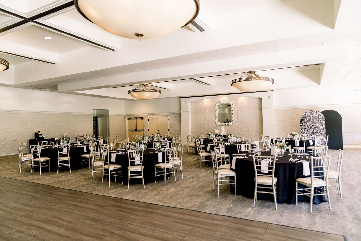 Modern wedding reception venue with elegant table settings and lighting.