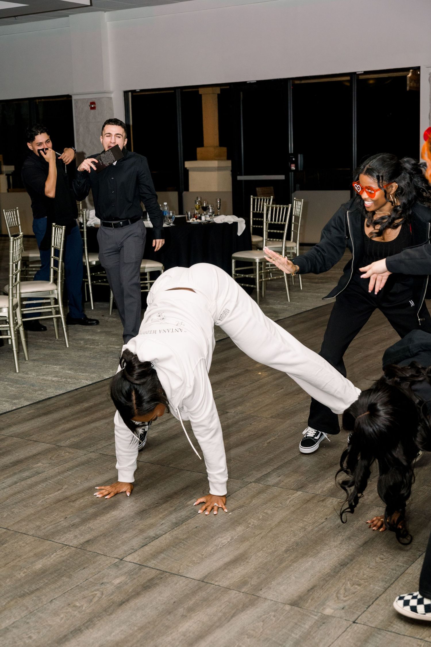 Dancers perform energetic breakdance moves on a dance floor during a celebration.