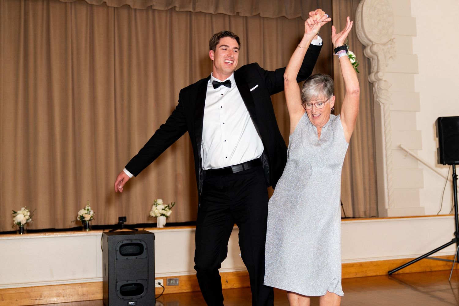 Joyful dancing at wedding reception with formal attire.