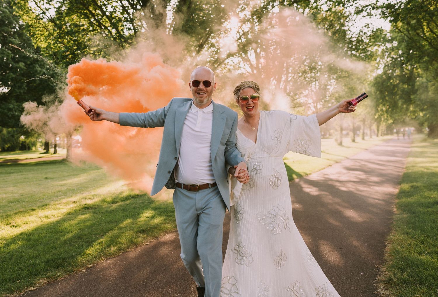 bride and groom doing couple photos outside with colour smoke bombs