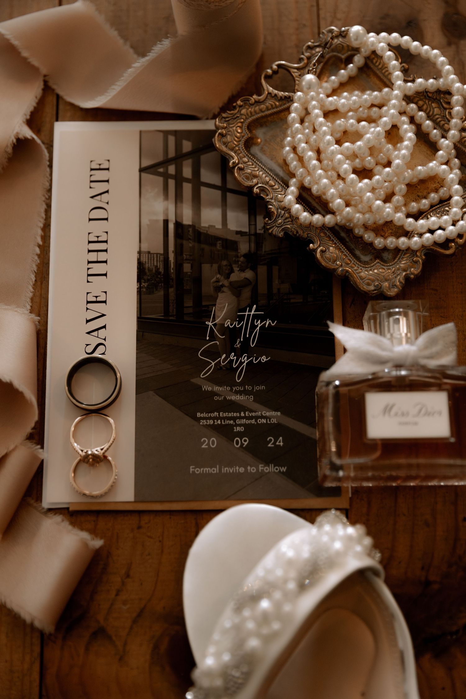 Wedding rings and save the date card with bridal accessories in warm sepia tones.