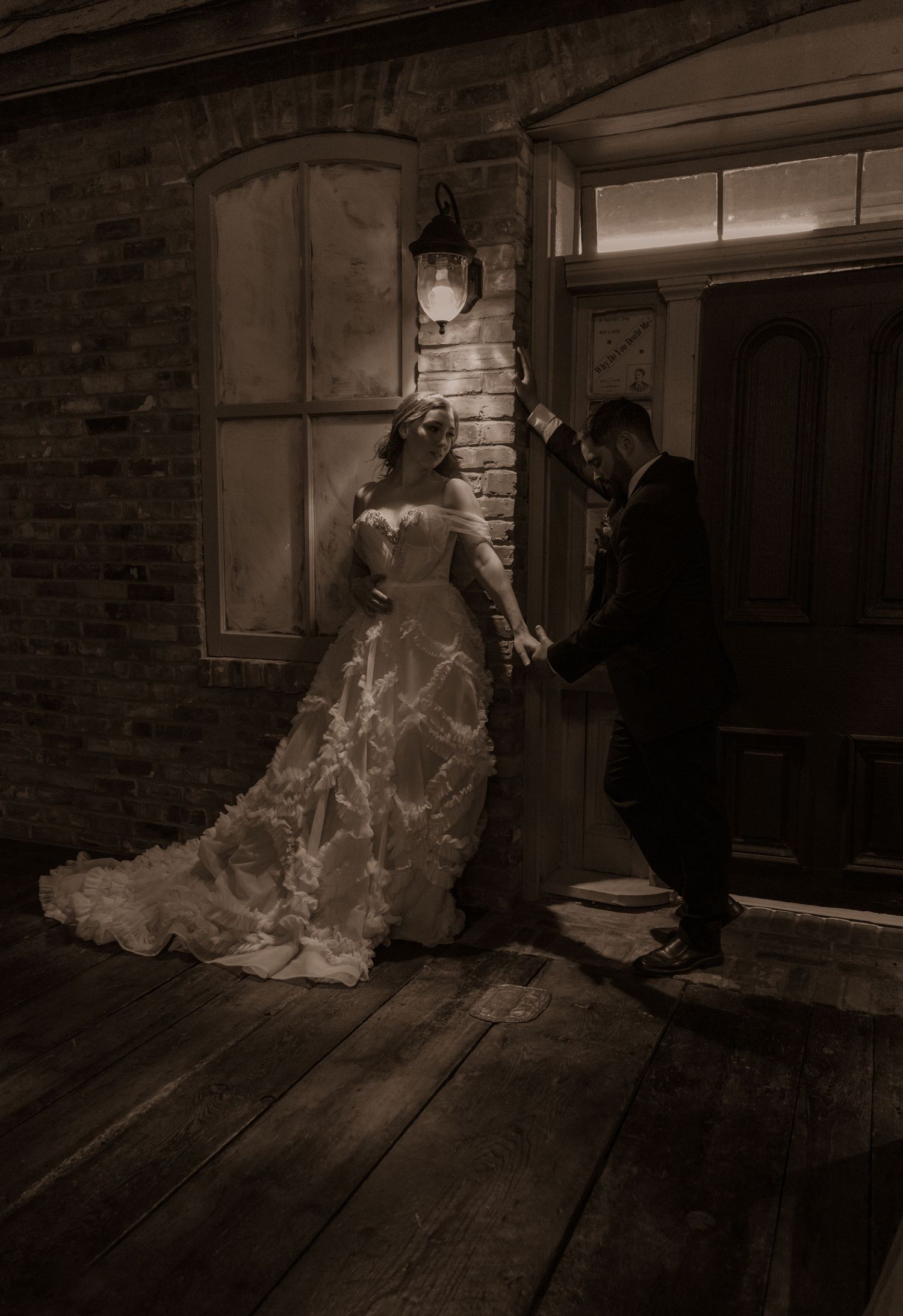 Stylized vintage wedding scene featuring bride in flowing gown and groom by rustic doorway.