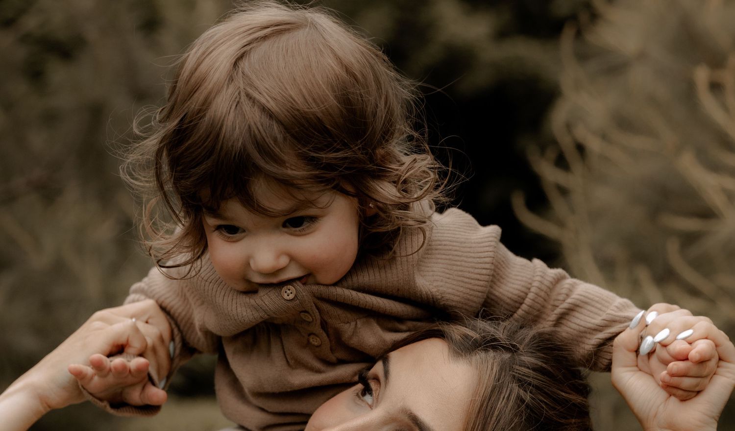 A tender playful moment captured in sepia tones as two people share joyful laughter together.