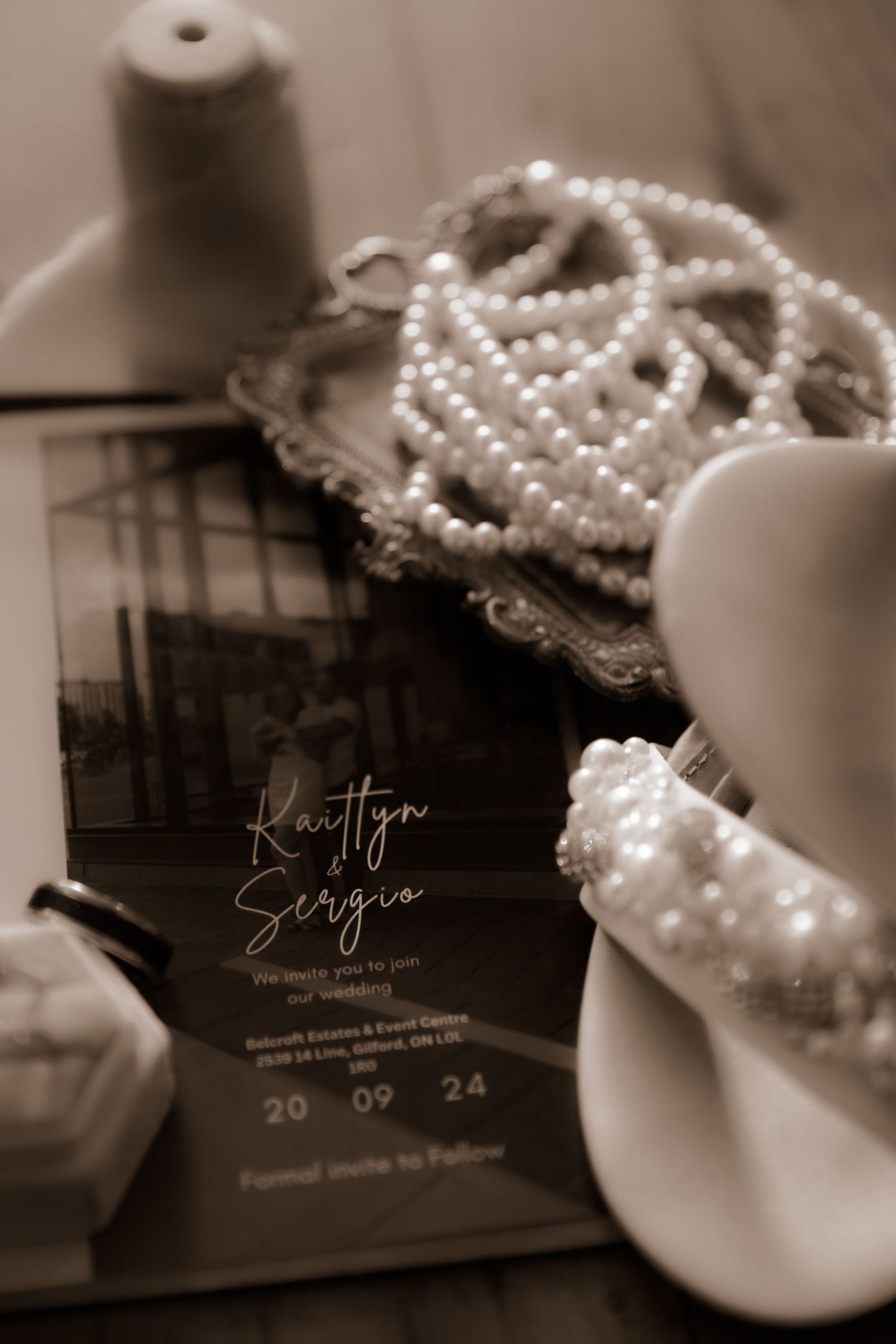 Wedding invitation with pearl necklace and decorative elements in soft focus.