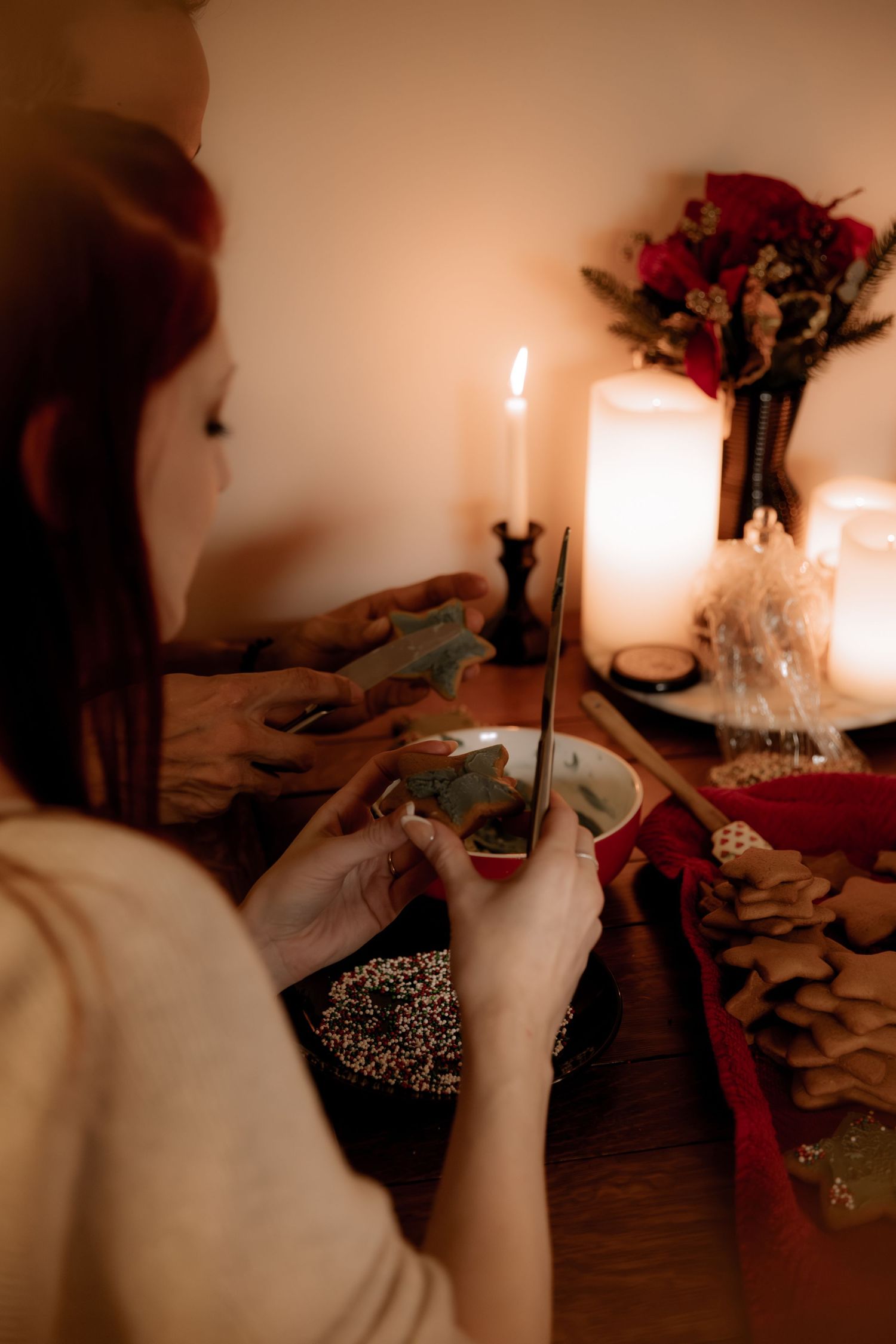 Romantic dinner setup with candles, flowers and someone enjoying a meal.