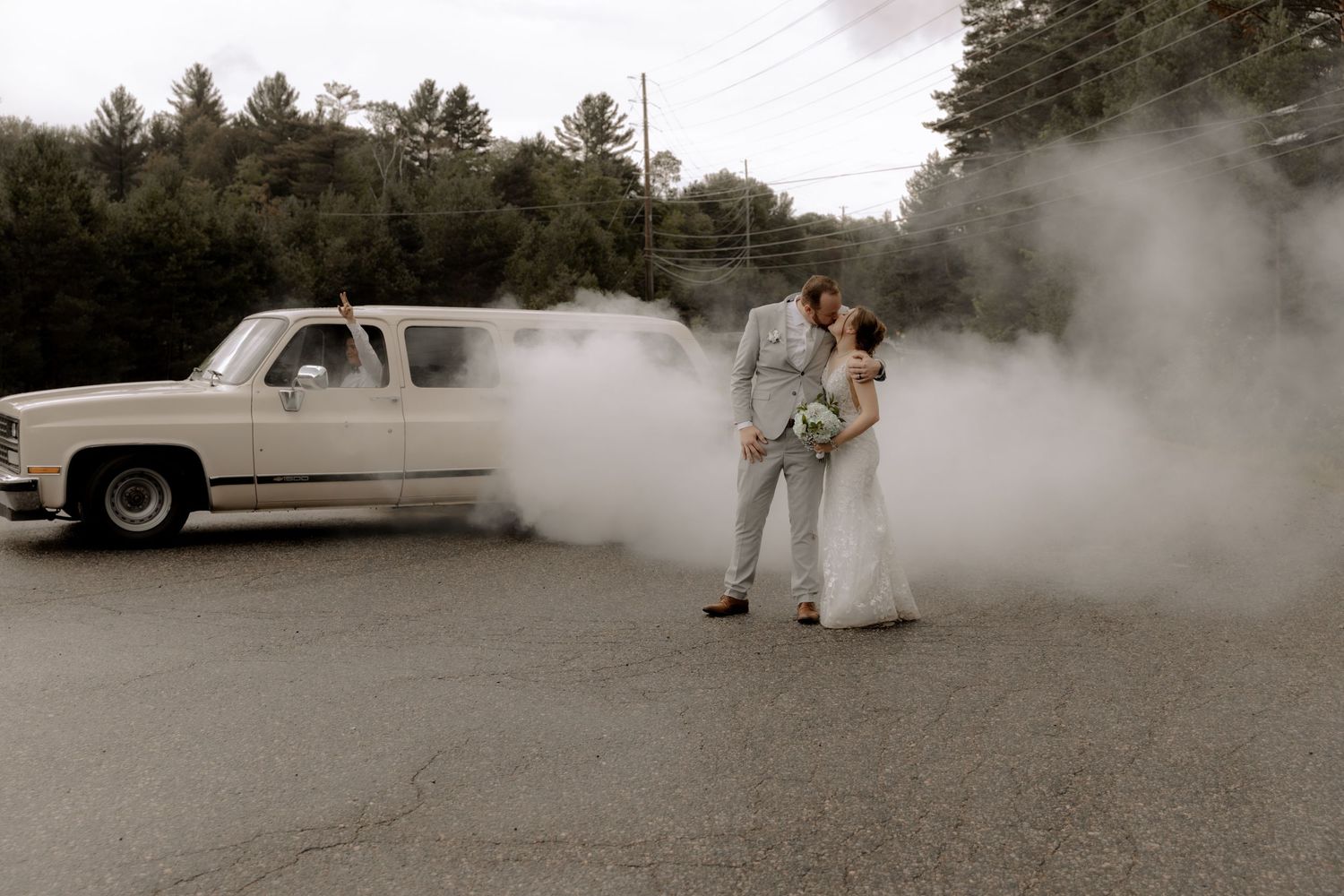 Wedding couple surrounded by smoke effects with vintage truck in parking lot.