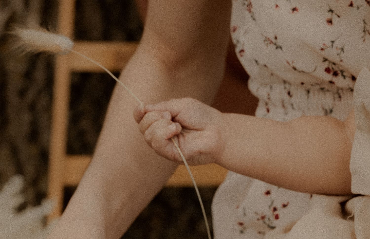 Someone knitting with yarn in a warm-toned setting, close-up view of hands holding needles.