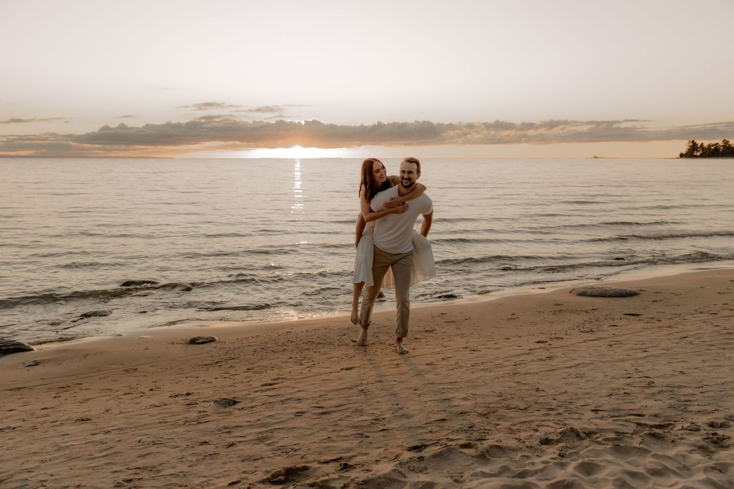 Playful beach scene with couple during golden hour sunset.